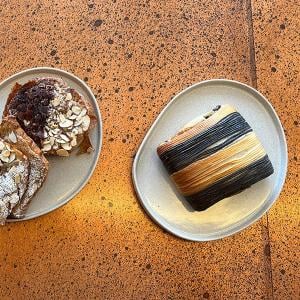 A pain suisse and almond croissants seen overhead on separate plates