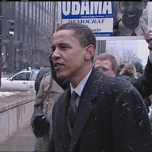 A young Barack Obama stands on the street while it snows