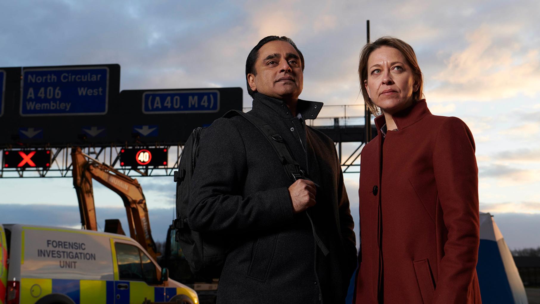 Sunny and Cassie work to identify a skeleton found off the side of an isolated roadway. Photo: Mainstreet Pictures for ITV and MASTERPIECE Sanjeev Bhaskar as DI Sunny Khan and Nicola Walker as DCI Cassie Stuart in Unforgotten. Photo: Mainstreet Pictures for ITV and MASTERPIECE