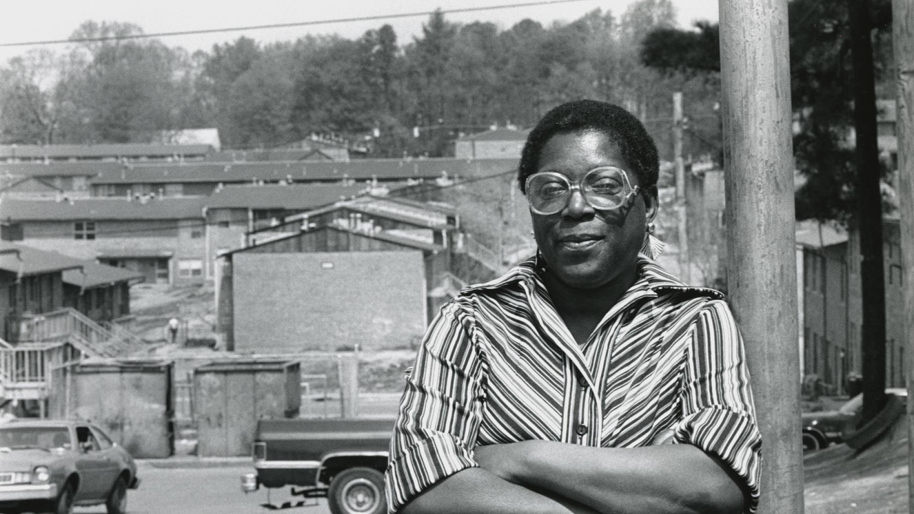 Eva Davis leans against a telephone pole, the buildings of of East Lake Meadows appear behind her. Atlanta, GA. September 8, 1986. 