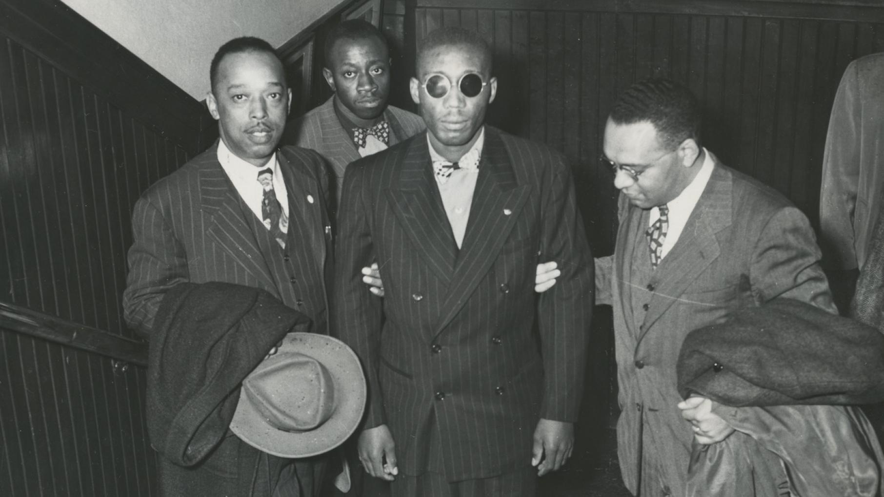 Leroy Carter, Isaac Woodard, and Donald Jones, NAACP assistant field secretary. Willie Mabry, Sgt. Woodard’s cousin. in background. Likely taken while Woodard was on his speaking tour with the NAACP. 10/1946. Photo: AFRO American Newspapers Archives