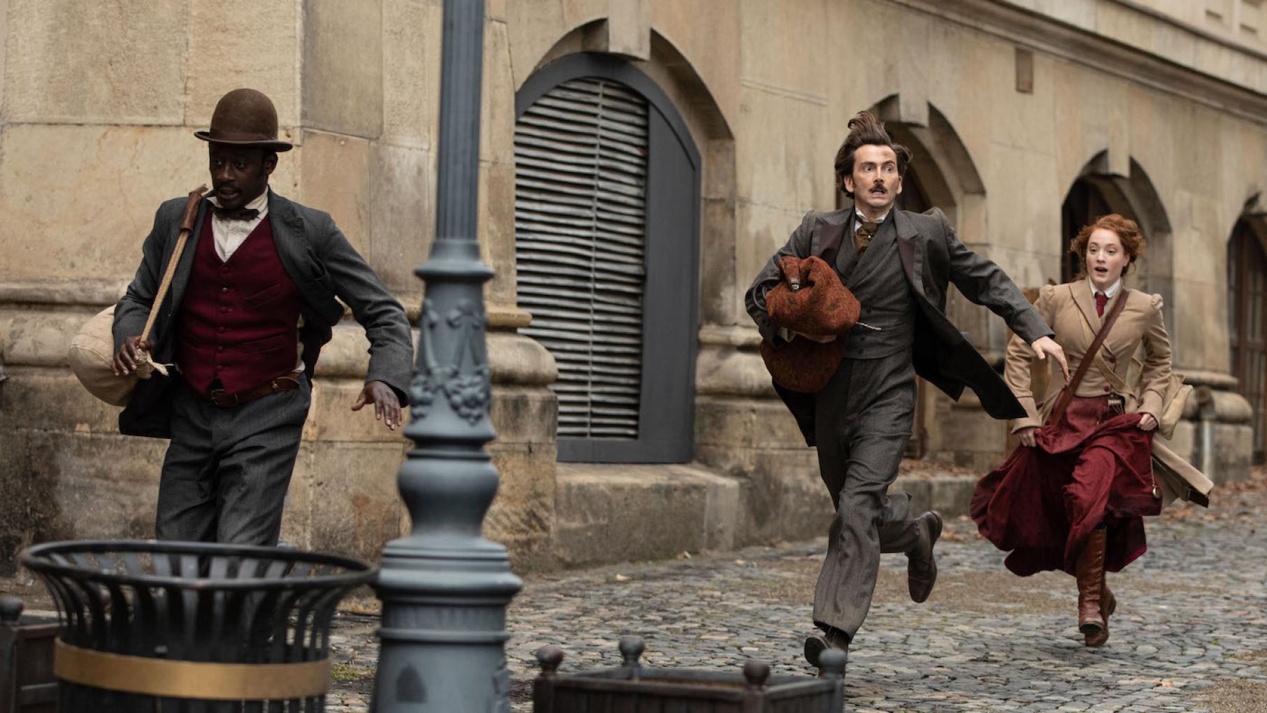 Phileas Fogg immediately runs into trouble on his attempt to circumnavigate the globe with the journalist Fix and valet Passepartout. Photo: Tudor Cucu - © Slim 80 Days / Federation Entertainment / Peu Communications / ZDF / Be-Films / RTBF (télévision belge) Passepartout, Fogg, and Fix flee police in Paris. Photo: Tudor Cucu - © Slim 80 Days / Federation Entertainment / Peu Communications / ZDF / Be-Films / RTBF (télévision belge)