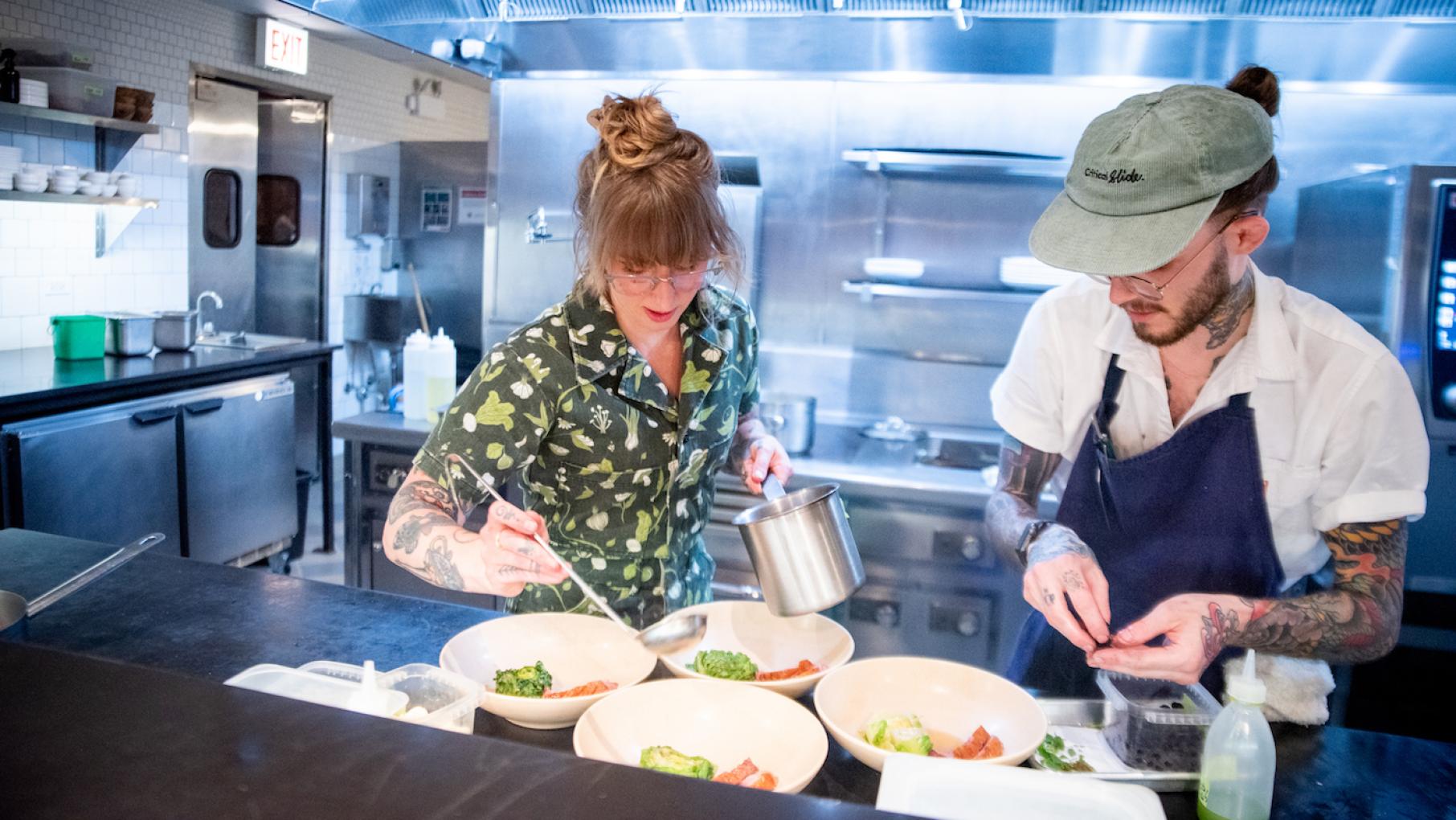 Wherewithall's chef de cuisine Tayler Ploshehanski does everything from ordering ingredients and creating the menu to plating food and stepping in to aid her line cooks. Photo: WTTW/Kathleen Hinkel Chef Tayler Ploshehanski, 33, left, works with line cook Tyler Damiani, 27, during the dinner service at Wherewithall at 3472 N. Elston Ave. in Chicago, Illinois. Photo: WTTW/Kathleen Hinkel