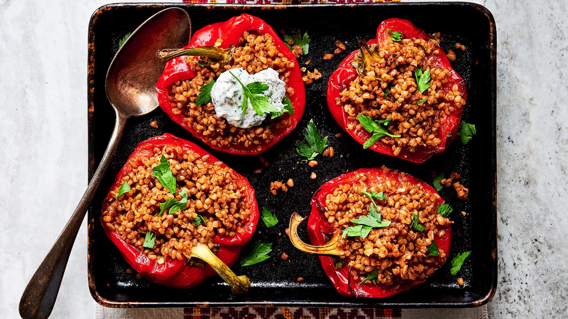 While Heifa Odeh says stuffed peppers aren't necessarily a Palestinian dish, she adds Palestinian flavors. Image: Doaa Elkady / Dine in Palestine Four bulgur stuffed peppers on a rectangular plate. Image: Doaa Elkady.