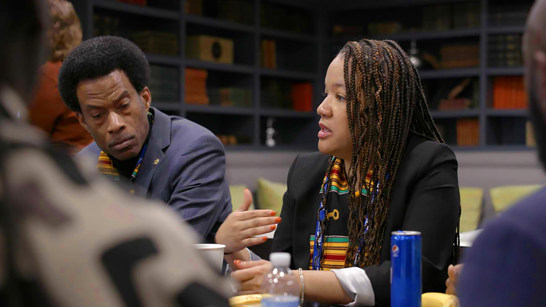 Robin Rue Simmons, right, sits at a table leading a discussion.
