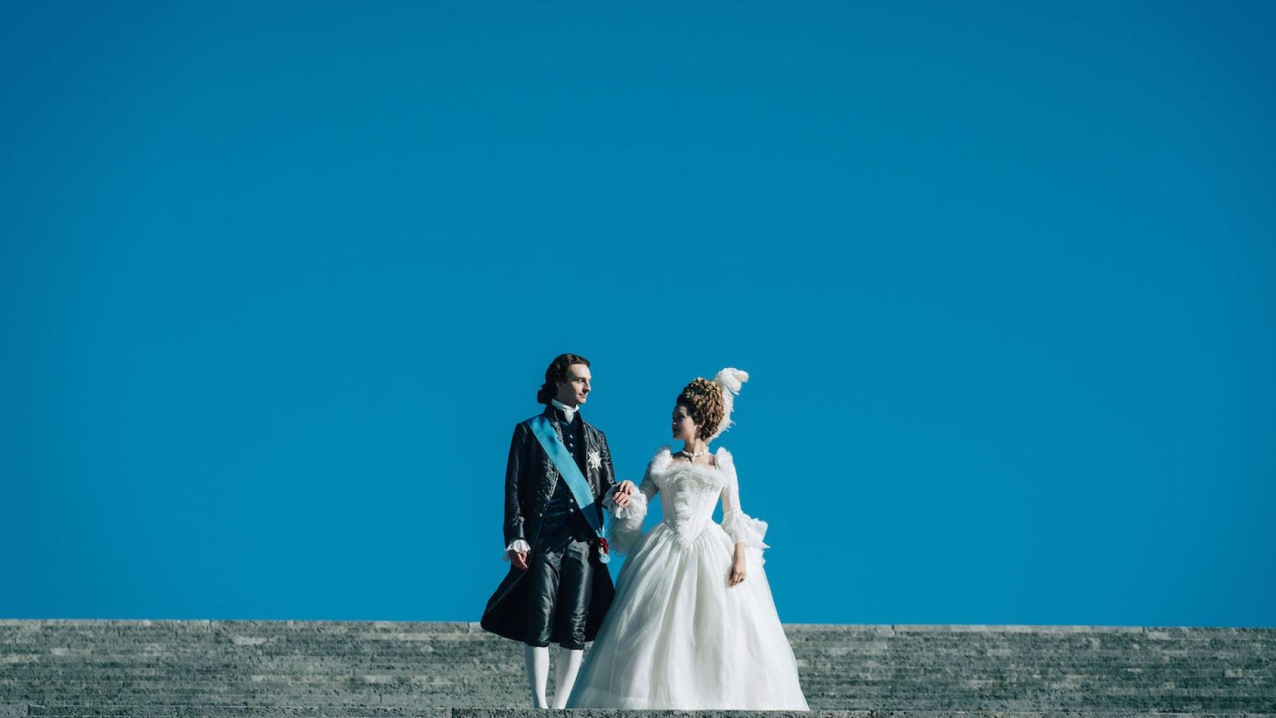 Louis-Auguste and Marie Antoinette are to debut in Paris. Photo: Caroline Dubois - Capa Drama / Banijay Studios France / Les Gens / Canal+ Louis Auguste and Marie Antoinette stand against a blue sky