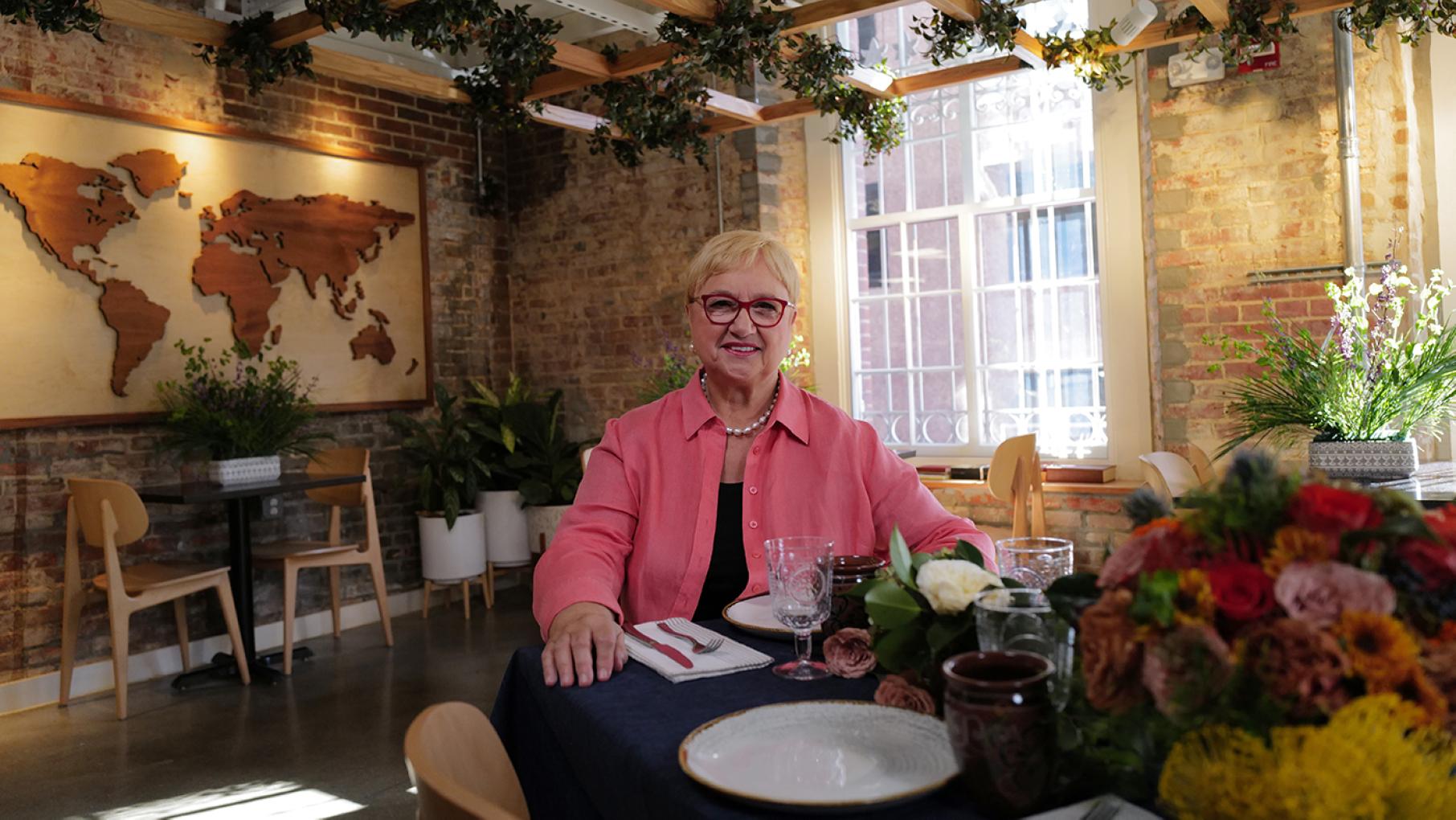 "America is made out of immigrants," says Lidia Bastianich, who is herself an immigrant to America. Photo: Meredith Nierman / GBH & Tavola Productions Lidia Bastianich sits at a set table near a map of the world