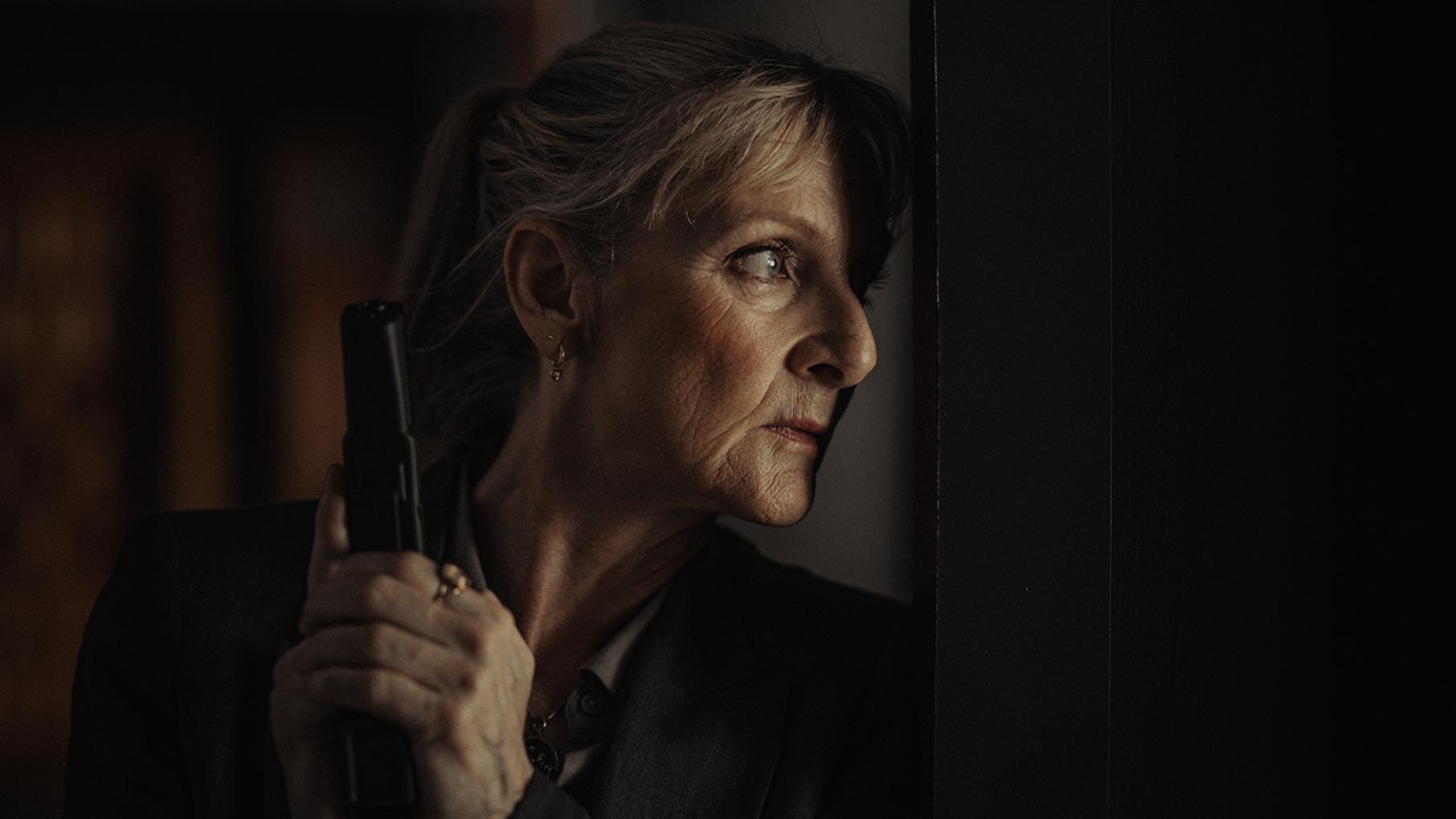 Hannah and Dubravka have a final showdown as they both fight to protect their grandson Hannah holds a gun in shadows