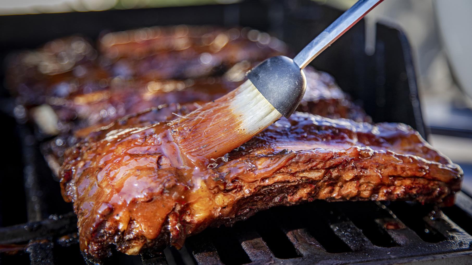A brush glazing ribs with sauce