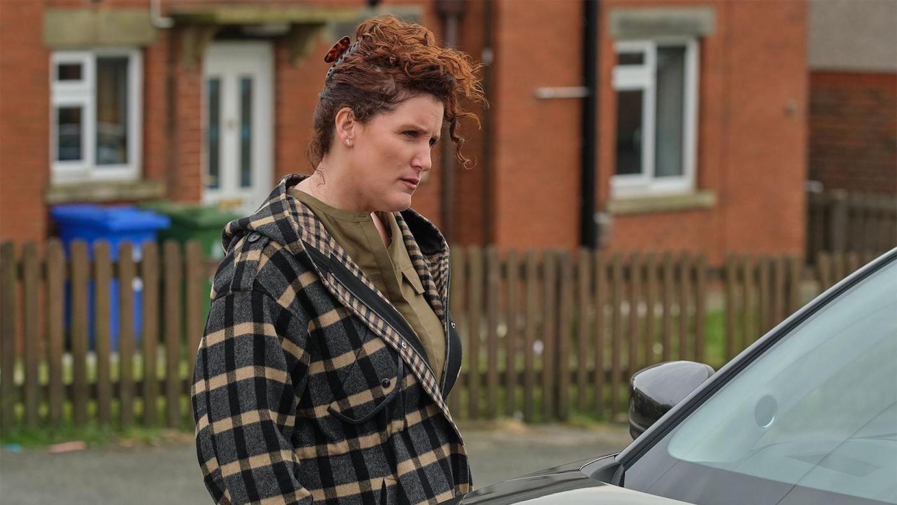 Carol Farman stands looking into a car