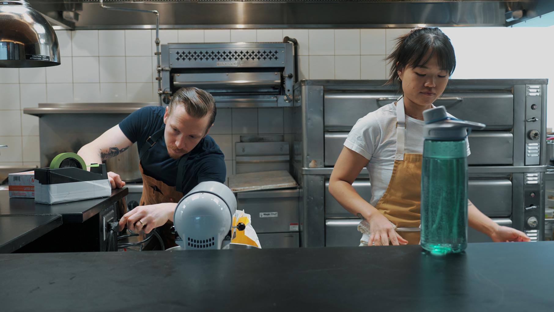 Mike Alesi and Jennifer Pou-Alesi got married after a long-distance romance right before the COVID-19 pandemic shut down the world. Photo: Courtesy Three Top Productions Mike Alesi and Jennifer Pou-Alesi work in a kitchen