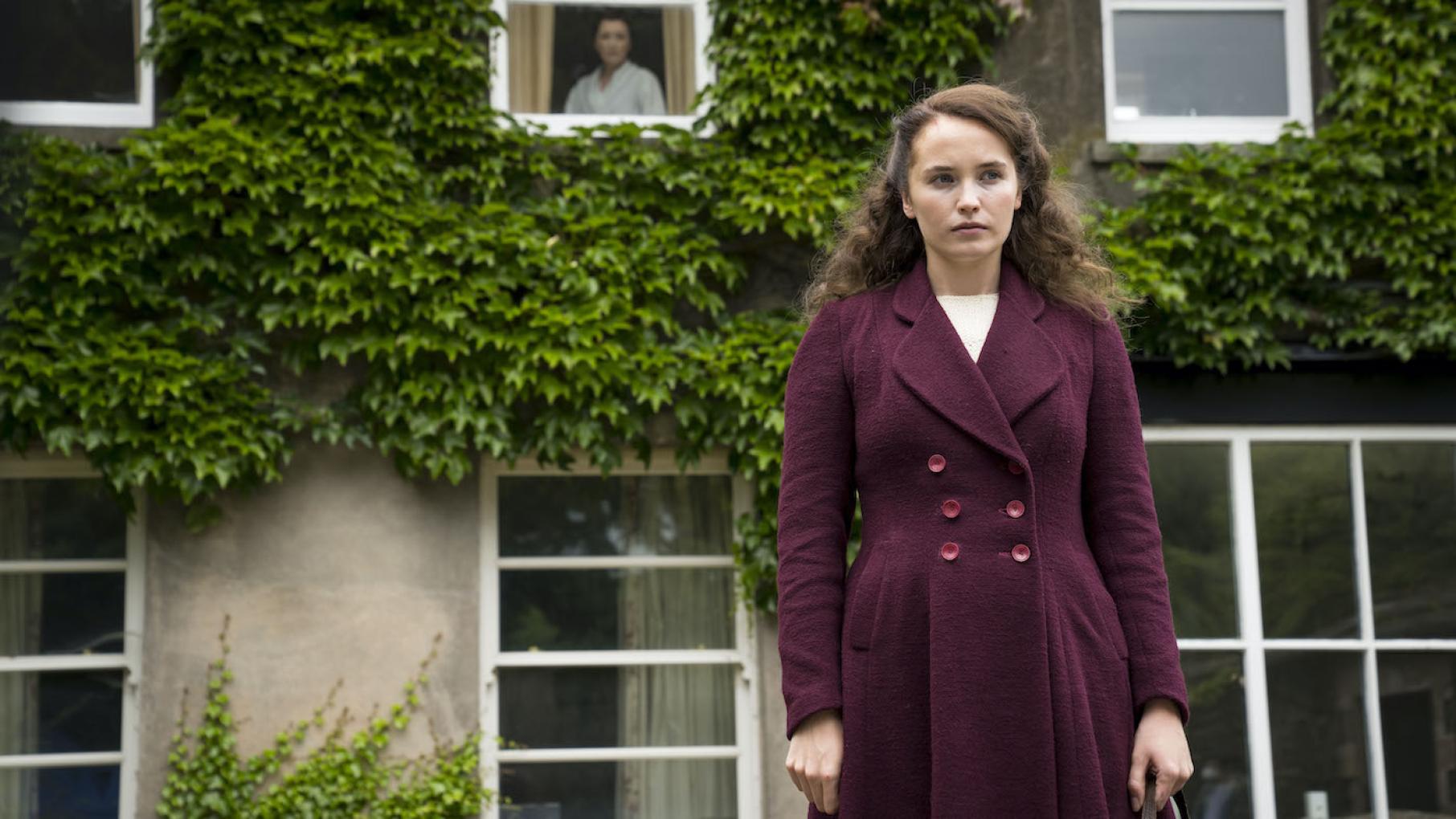 Lois walks away from a house with Robina in a second story window