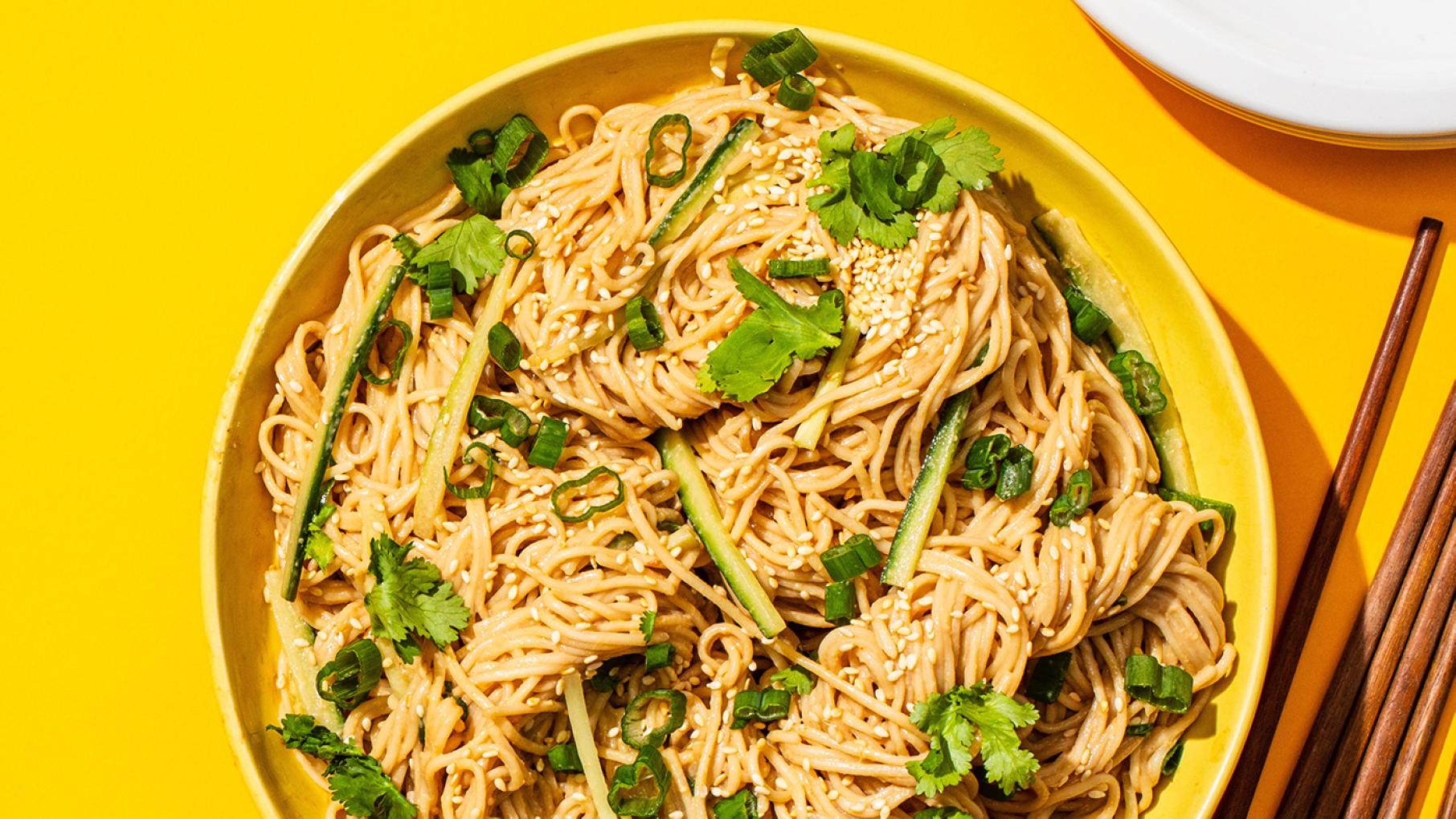 Cold Sesame Noodles are one of the simplest dishes in 'A Very Chinese Cookbook,' but also "one of the most delicious," its author Kevin Pang says. Credit: Kevin White for America's Test Kitchen A bowl of cold sesame noodles topped with cilantro, scallions, and cucumber in a yellow bowl on a yellow background