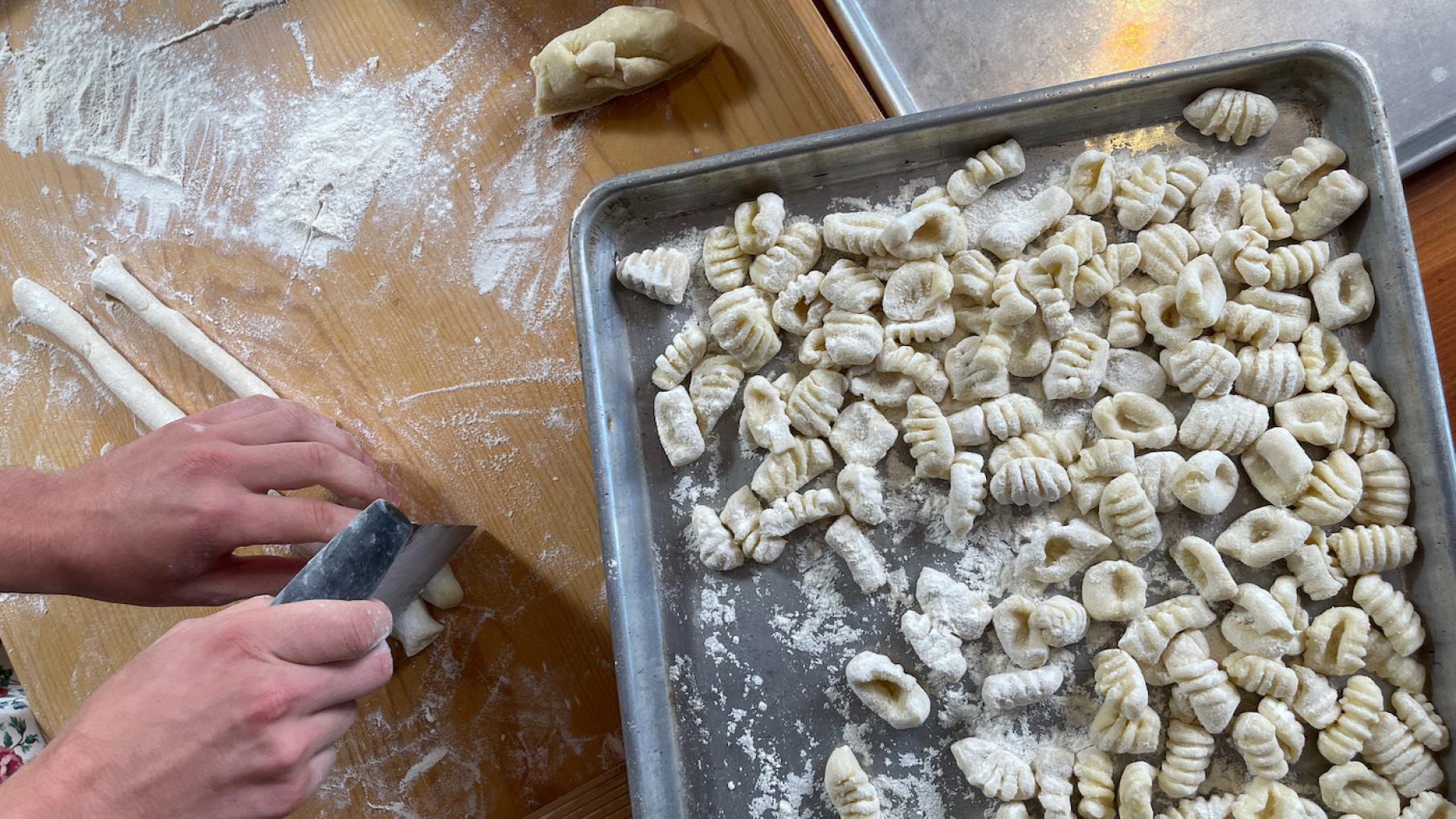 In '25 Years with Lidia,' Lidia Bastianich makes gnocchi with her grandchildren. Credit: Erika Heymann for WGBH Uncooked potato gnocchi sit on a tray while hands cut more from dough