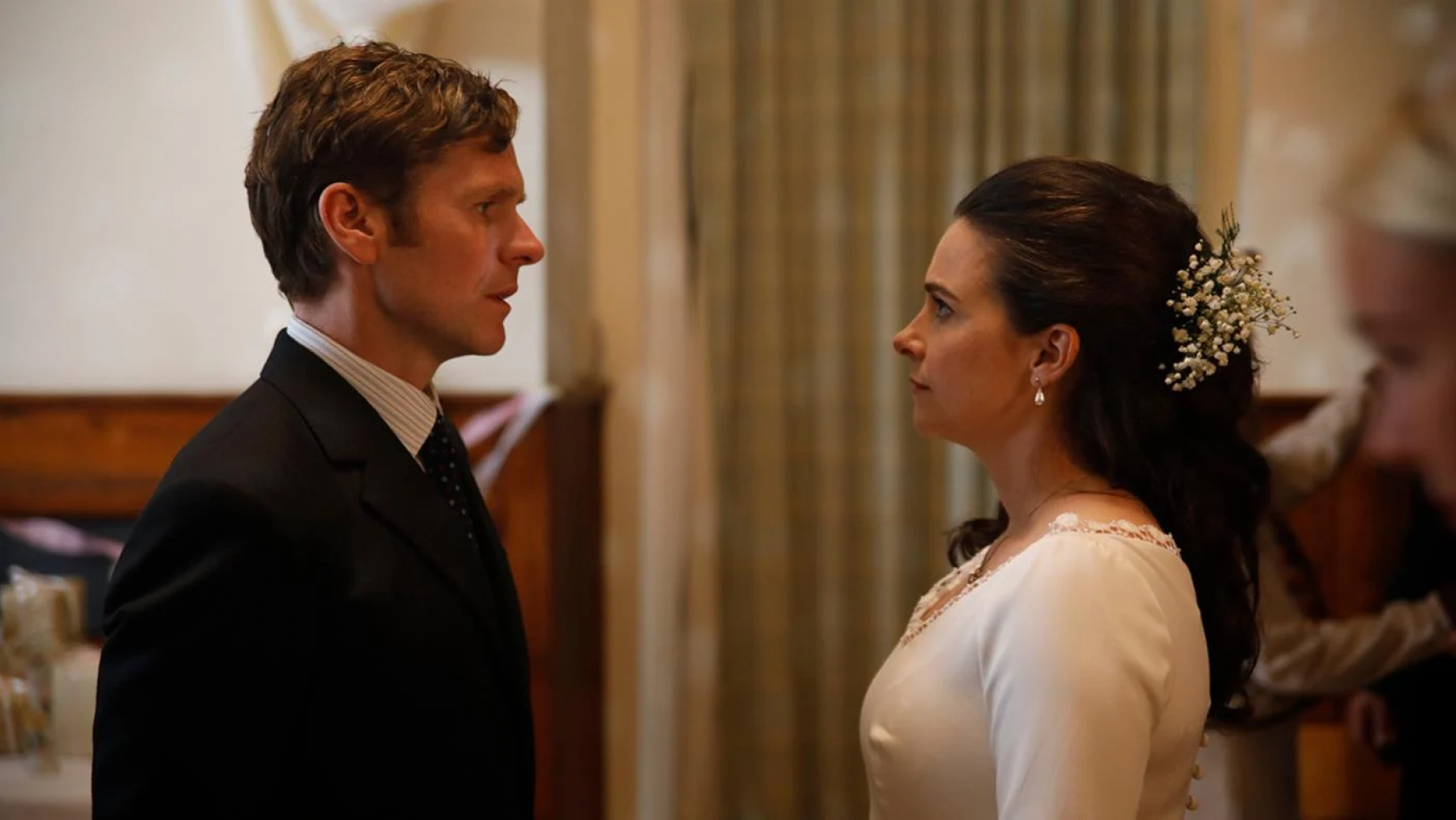Joan in a wedding dress faces Morse in a suit