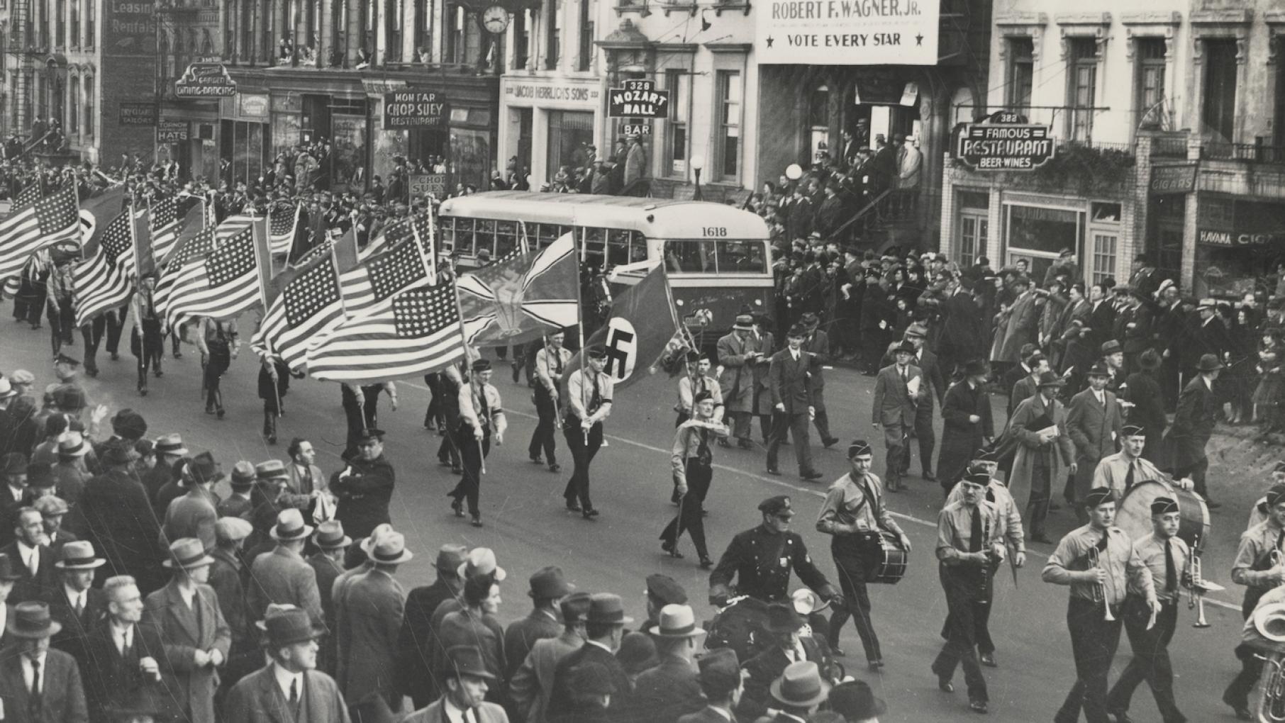 A German American Bund parade in New York City on East 86th Street. Oct. 30, 1937. Credit: Library of Congress A parade down a crowded Manhattan street in the 1930s featuring American flags and a swastika in a black and white photo