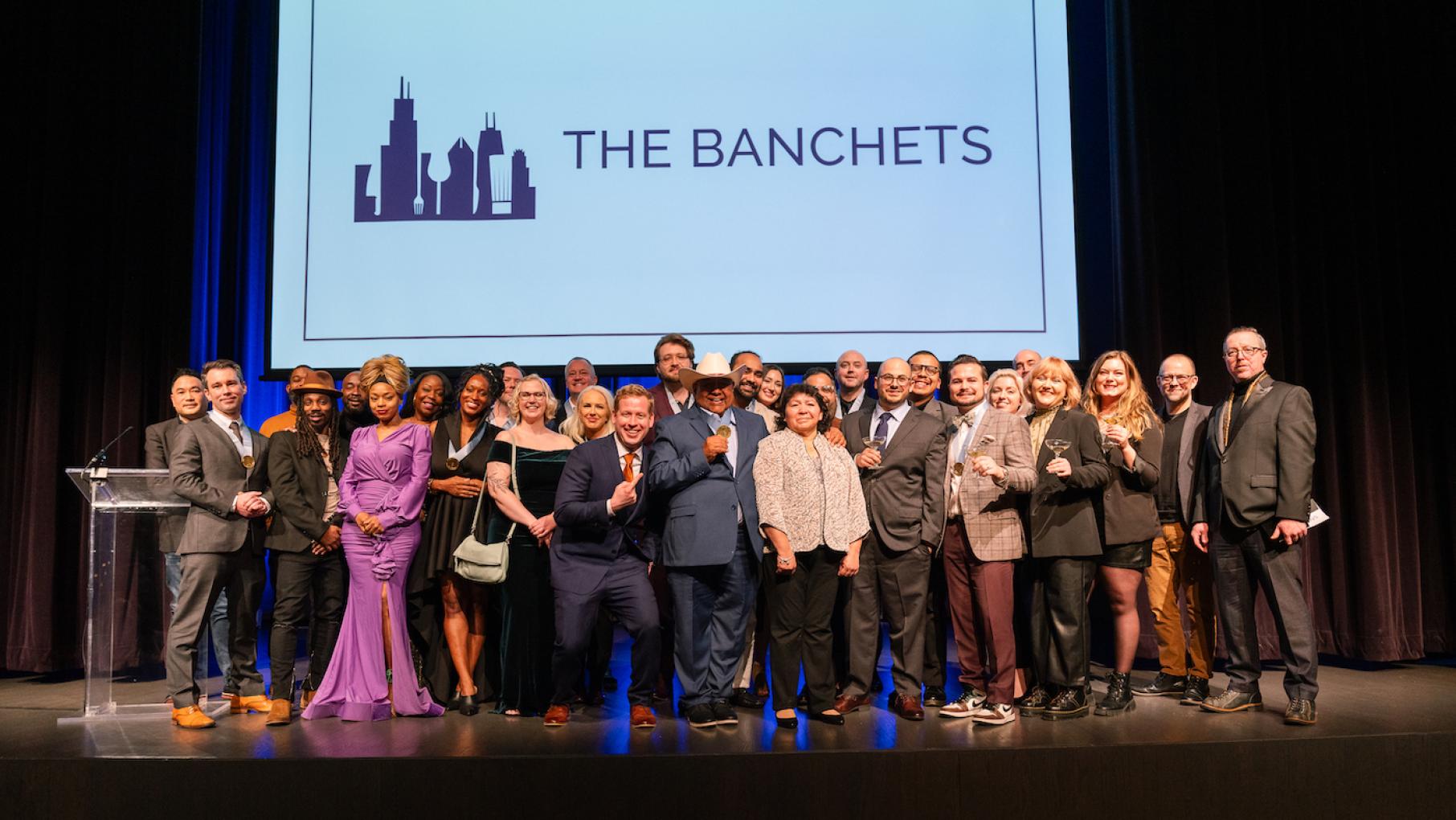 The winners of the 2024 Jean Banchet Awards for Culinary Excellence in Chicago. Credit: Kristen Mendiola, MADN Agency The winners of the Jean Banchet Awards pose onstage under a screen that says The Banchets