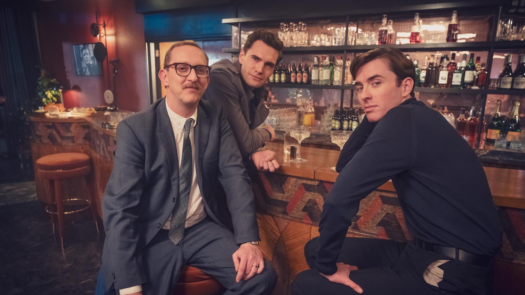 Tony, Clive, and Bill sit at a bar and mug for the camera