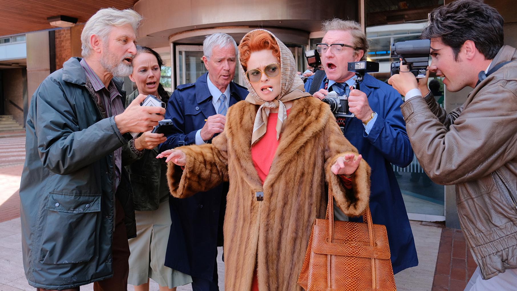 Helena Bonham Carter in character as Noele "Nolly" Gordon being photographed by paparazzi.