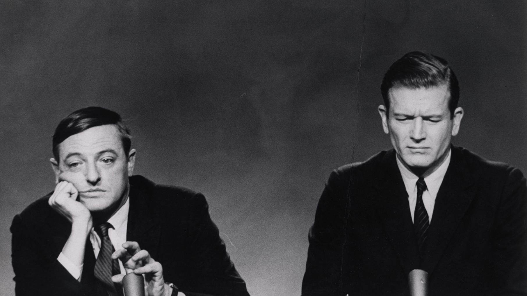 William F. Buckley Jr. (at left) and John V. Lindsay during a New York City mayoral debate in 1965. William F. Buckley, Jr. Papers (MS 576). Manuscripts and Archives, Yale University Library William Buckley looks bored behind a mic while John Lindsay looks annoyed next to him