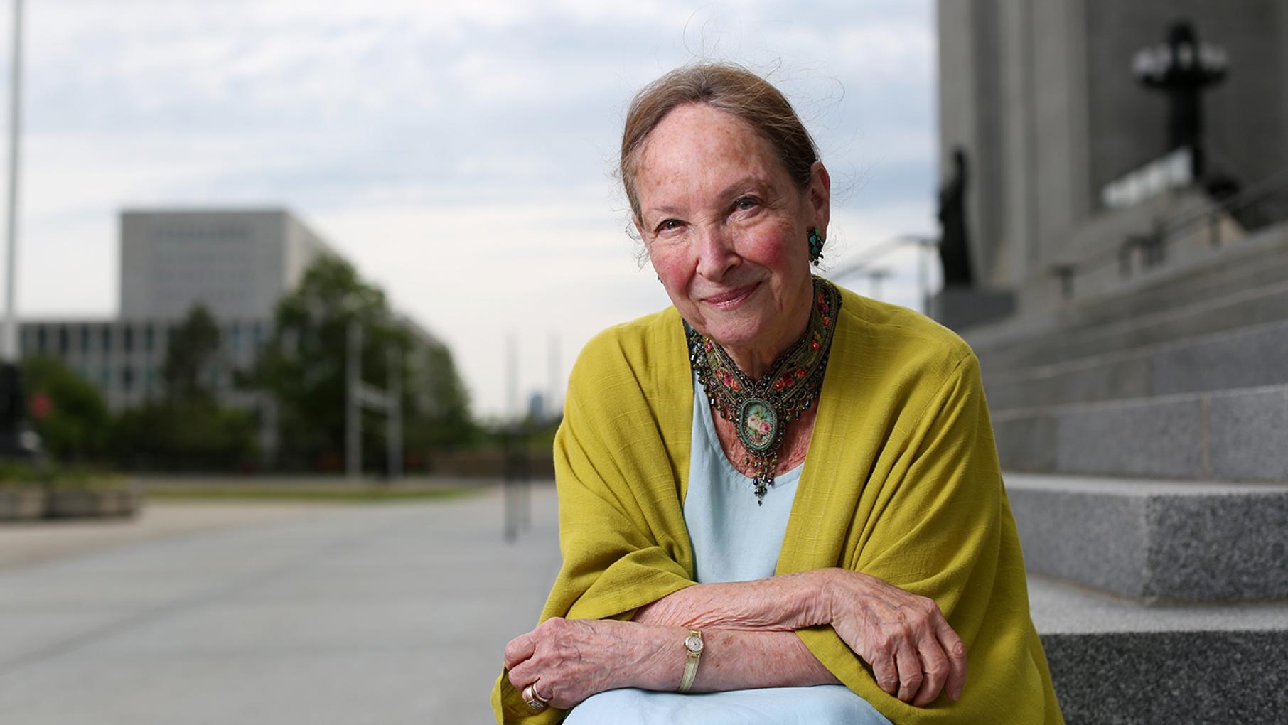 Rosalie Abella sits and smiles on the steps of the Supreme Court of Canada