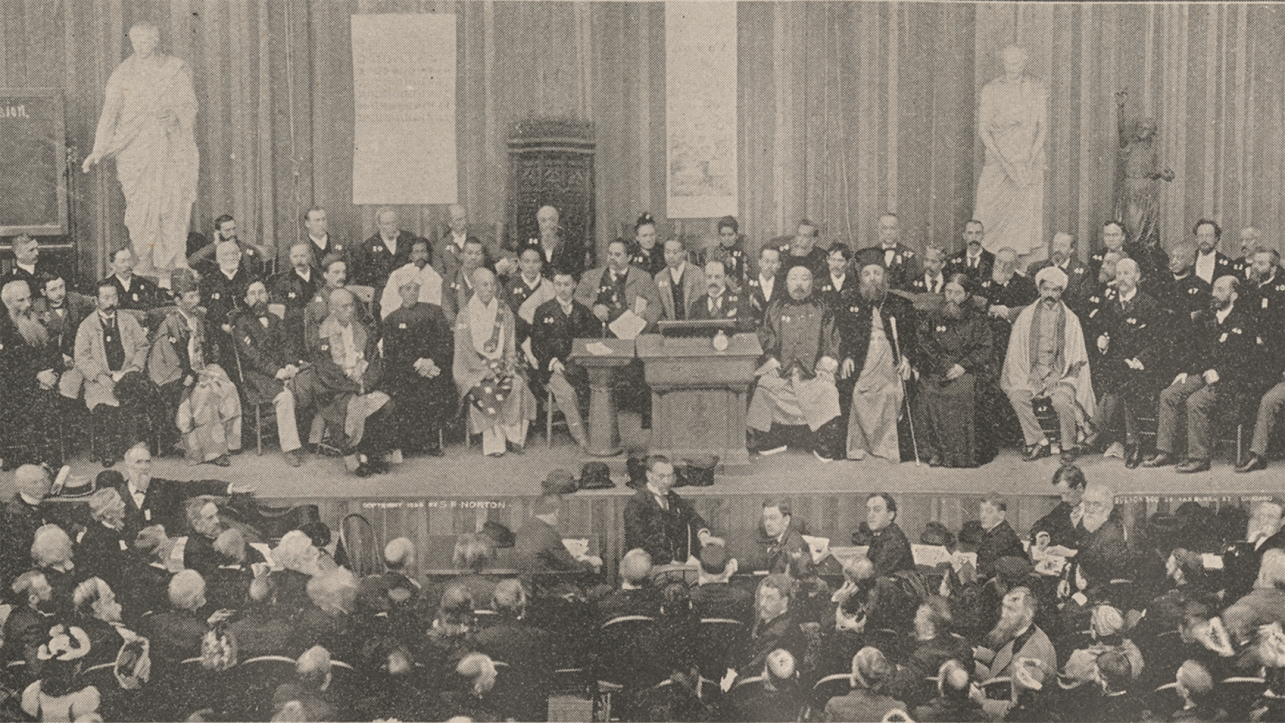 Group photo of scene at one of the sessions of the Parliament from the book The World's Parliament of Religions, Chicago, Illinois, 1893. Credit: Chicago History Museum, ICHi-062640 A group of men sit on a stage in front of other delegates in a black and white photo