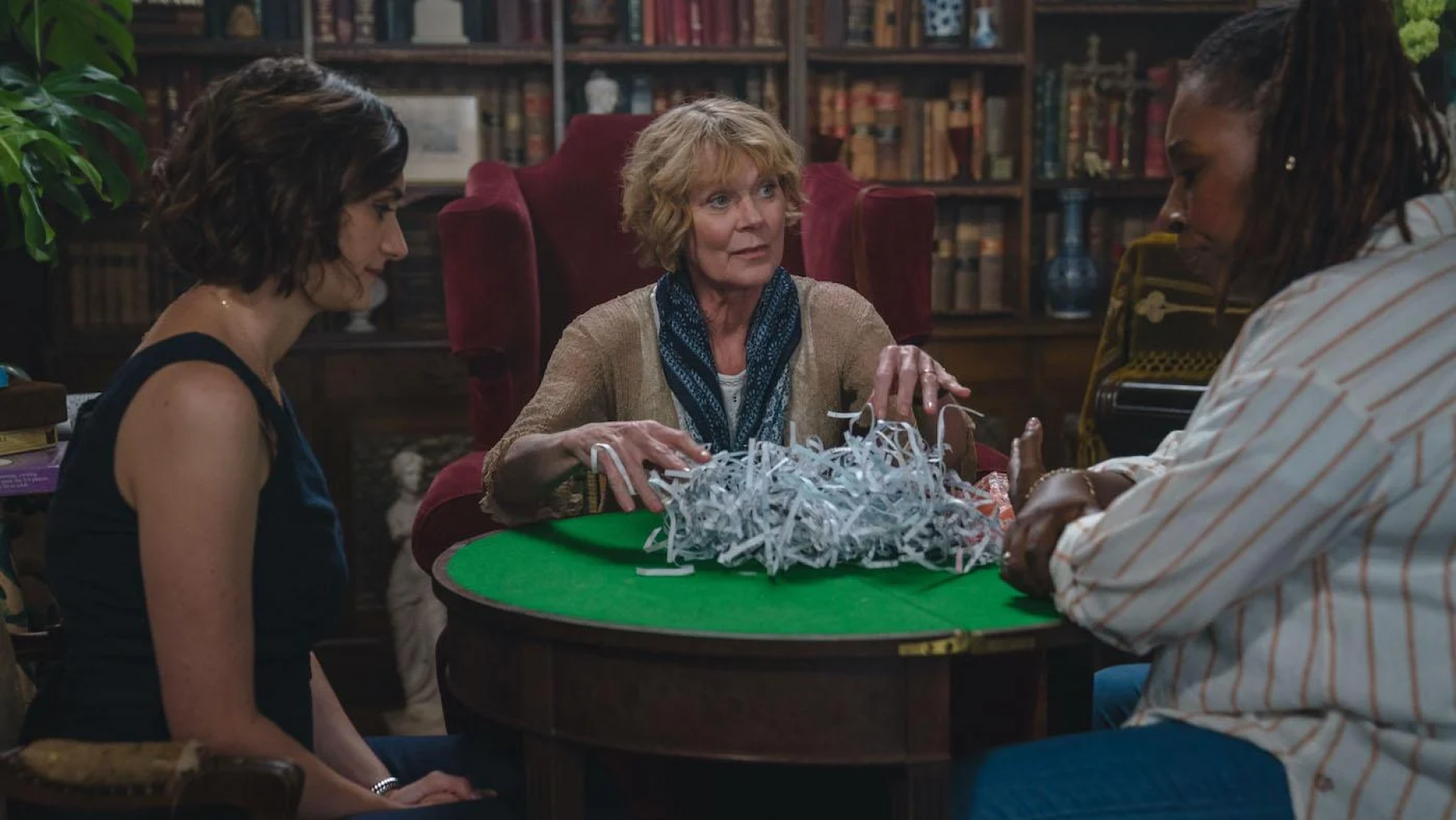 Becks Starling, Judith Potts, and Suzie Harris are the initial members of the 'Marlow Murder Club.' Credit: Masterpiece Three women sit around a table that has shredded paper on it
