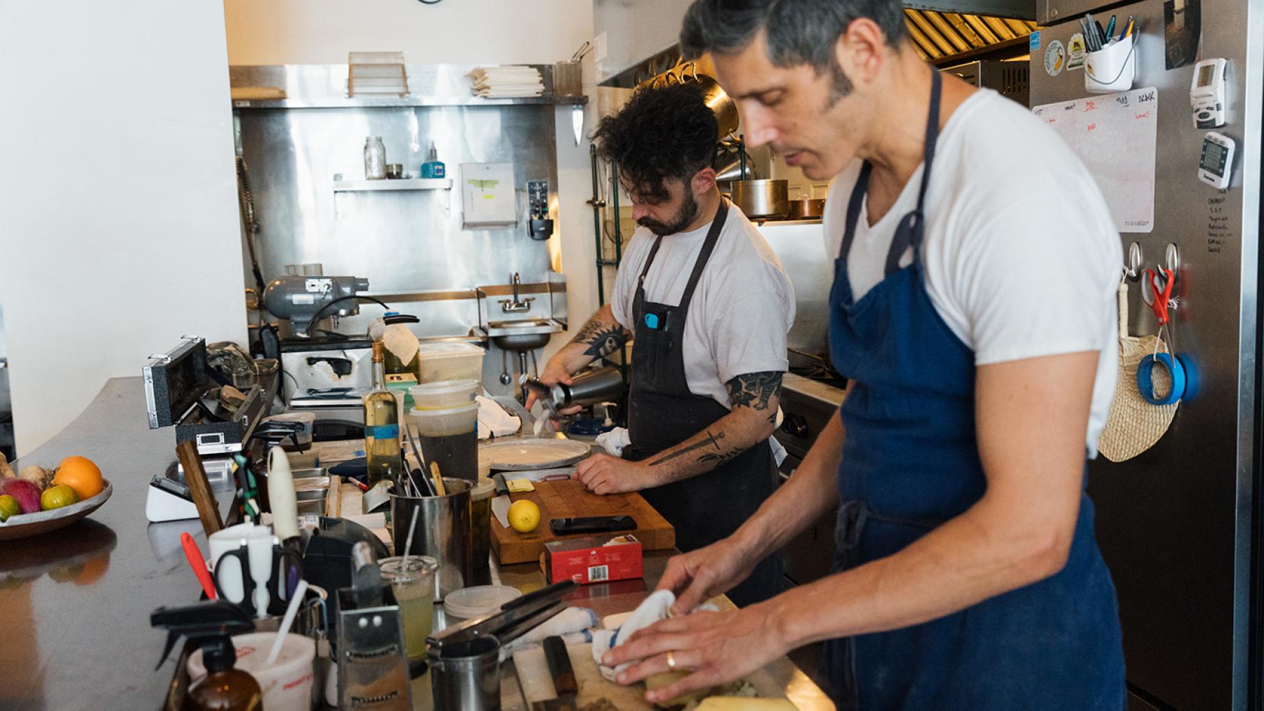 At Cellar Door Provisions, Ethan Pikas and Alex Cochran are constantly changing the menu by riffing on flavor combinations and adapting to fresh produce. Credit: Sandy Noto for WTTW Two men work side by side in a kitchen