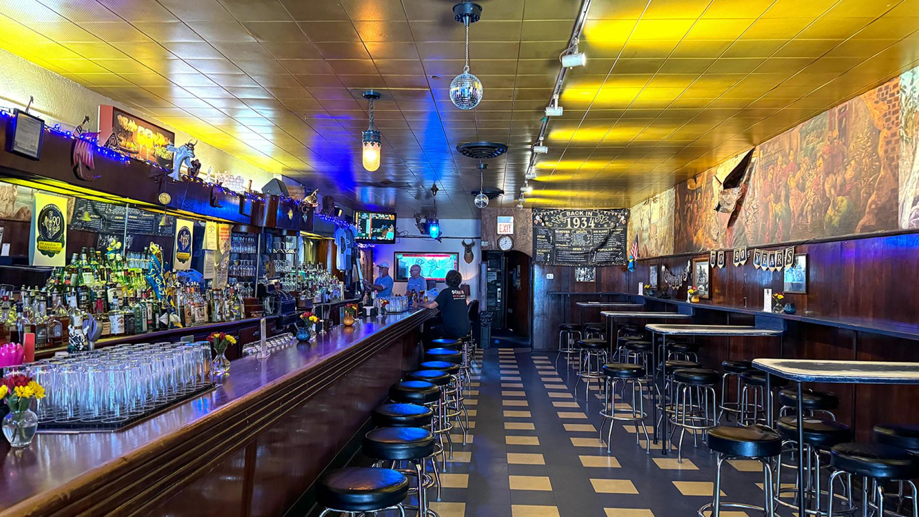 Simon's Tavern began as a basement speakeasy during Prohibition and has been open legally for 90 years. Credit: Maggie Hennessy for WTTW The blue- and yellow-lit interior of the old bar Simon's Tavern in Chicago' Andersonville