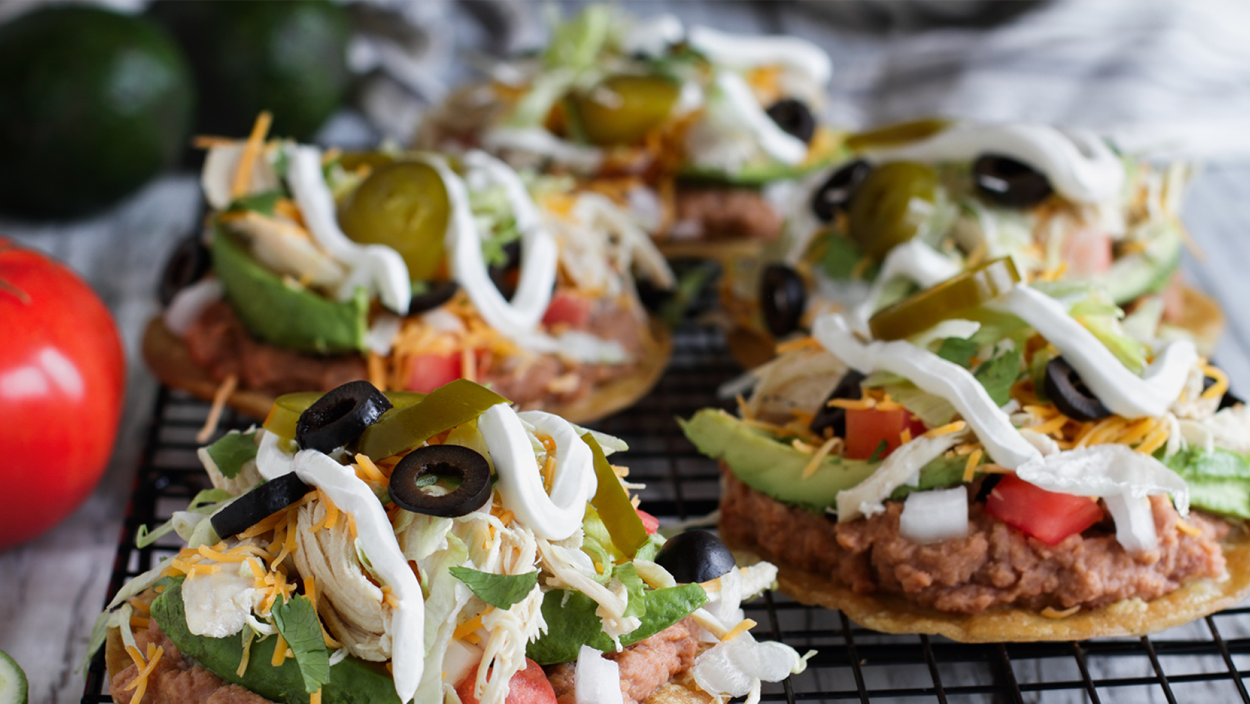 Tostados Tostados with lettuce, tomato, avocado and more served on a table