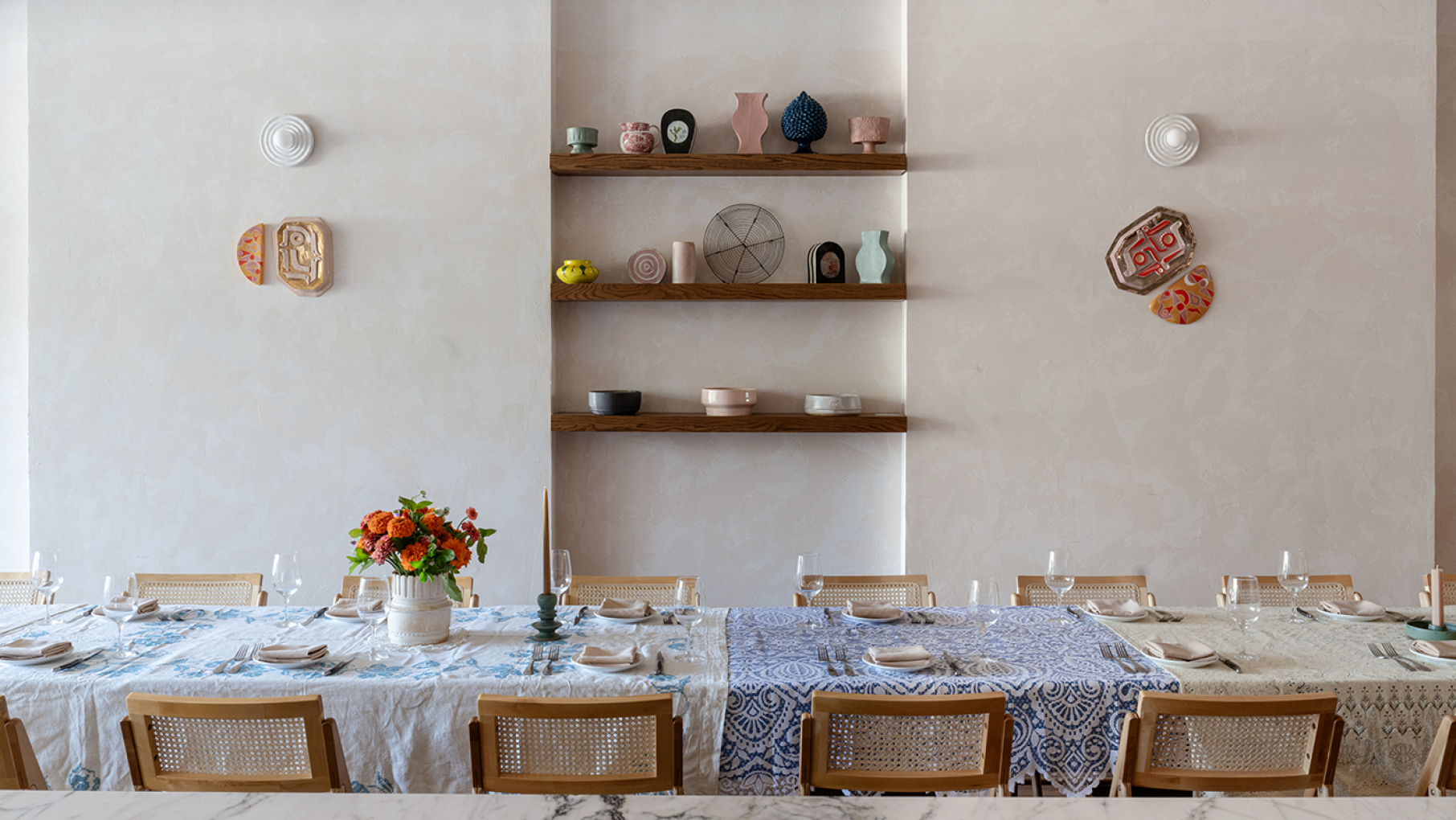 LOULOU hosts special menus, guest chefs, musical performances, and other creative events that its parent Lula Cafe can't. Credit: Wade Hall A set table in front of a wall with shelves