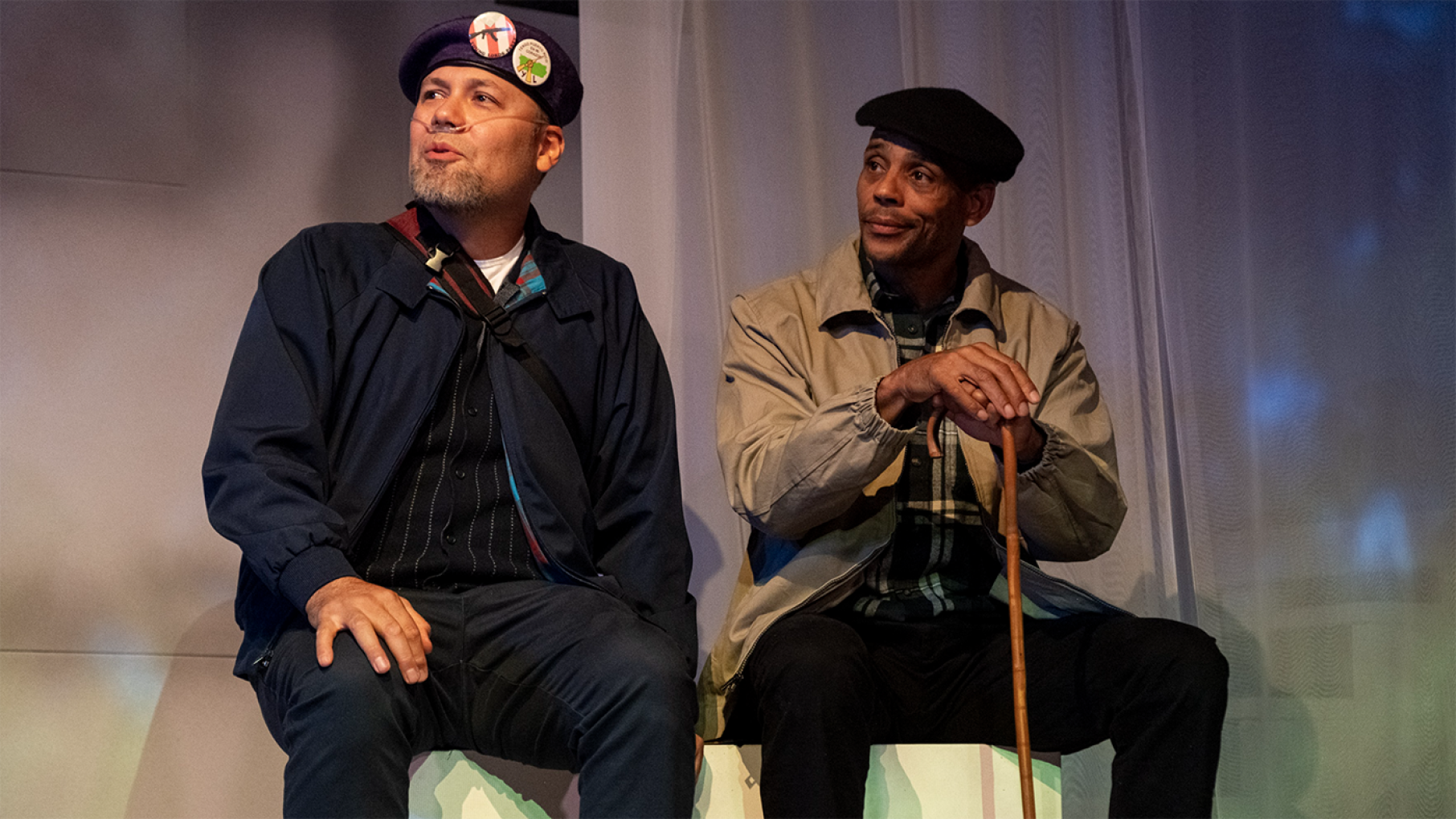 Ivan Vega, left, as José “Cha Cha” Jiménez and Stanley King as Billy “Che” Brooks on stage in “Chicago Lore(s).” Credit: Joel Maisonet / UrbanTheater Company Ivan Vega, left, as José “Cha Cha” Jiménez and Stanley King as Billy “Che” Brooks sitting on a bench on stage in “Chicago Lore(s).”