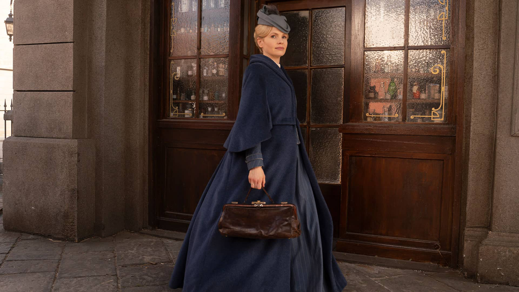 Miss Scarlet is back for a fifth season. Credit: Masterpiece Miss Scarlet in a blue outfit holding a bag