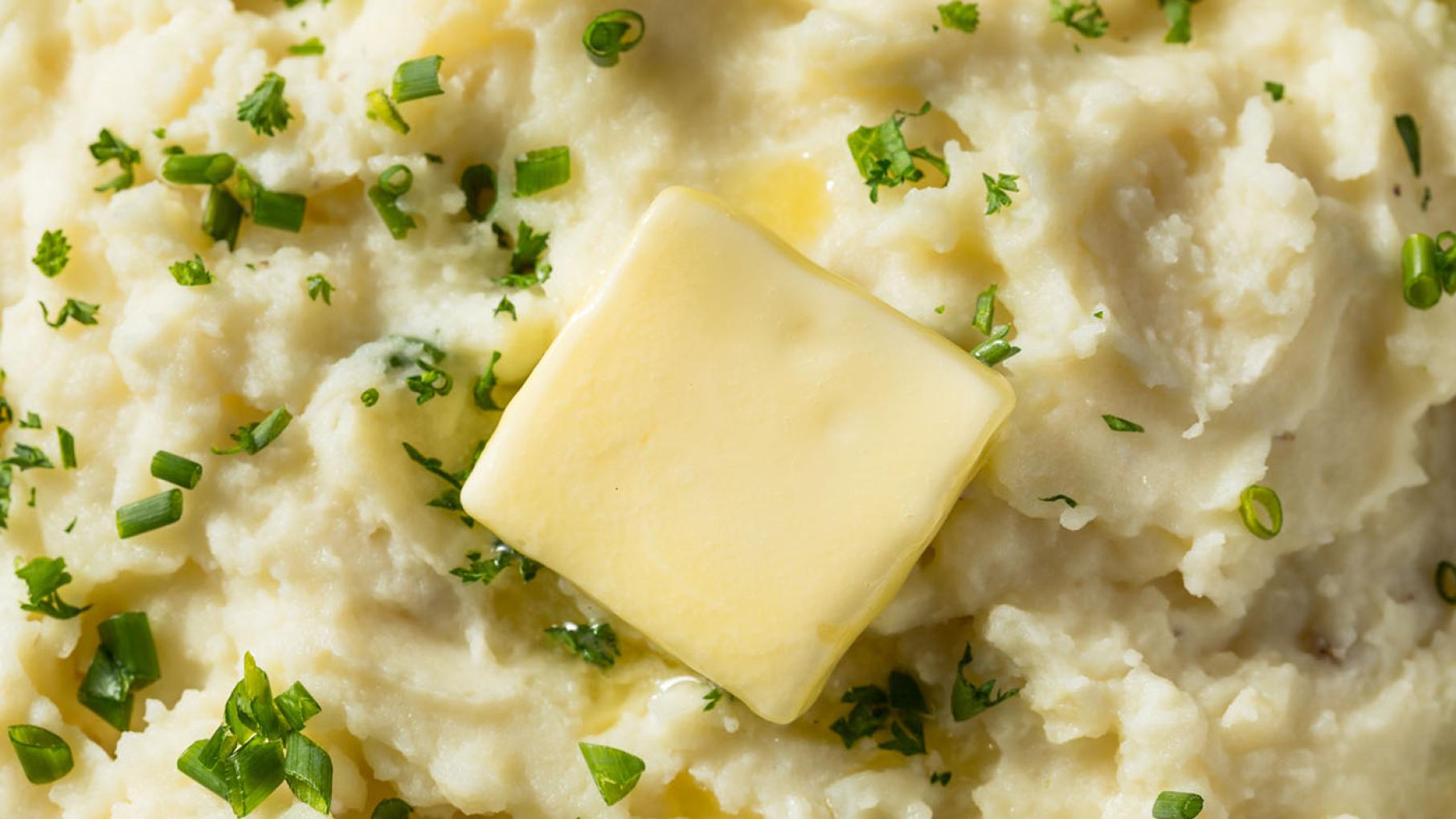 Credit: iStock A close-up of a pat of butter over mashed potatoes with chives