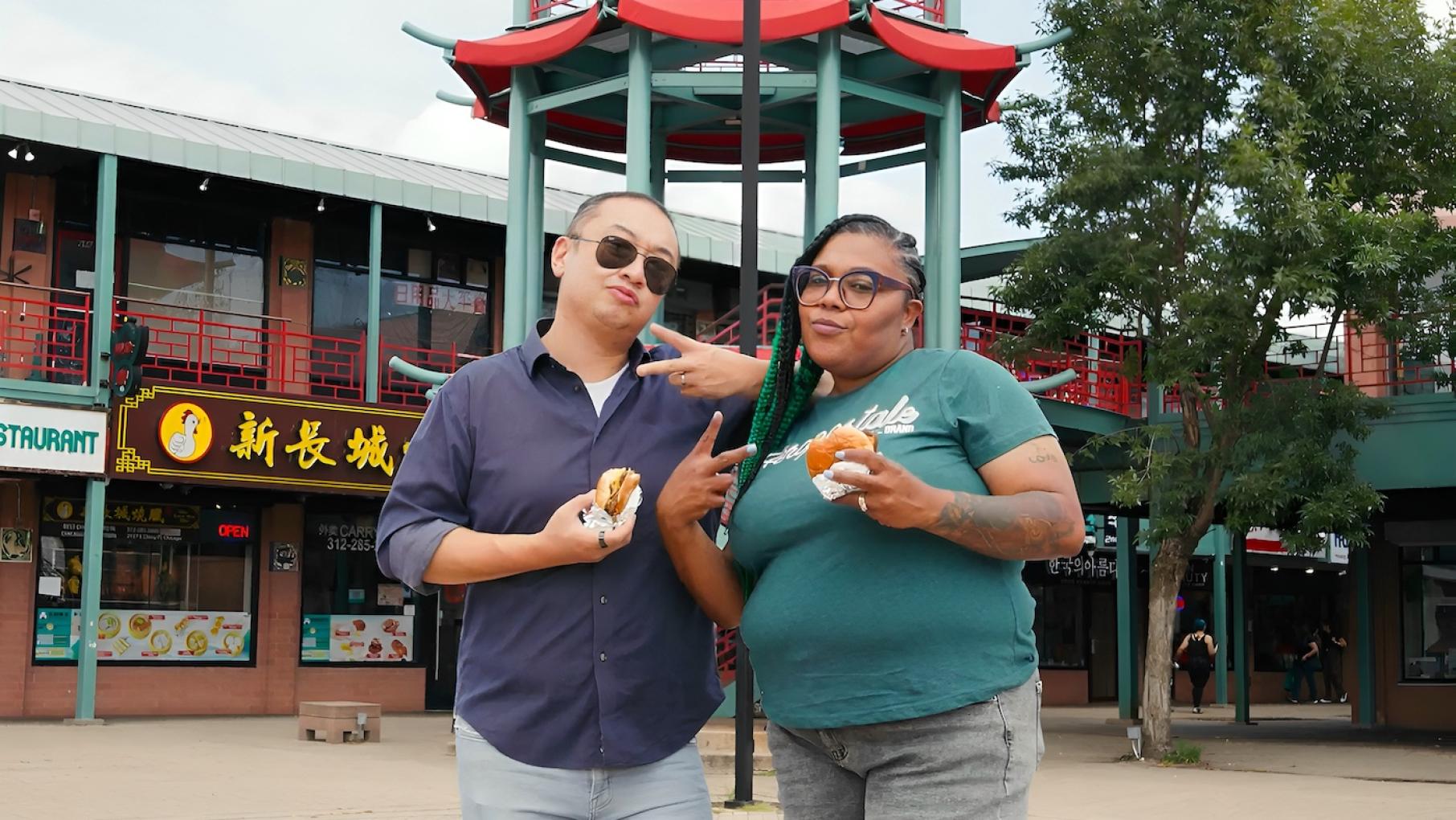 Kevin Pang and Poochie from The Wiener's Circle sample burgers around Chicago in the new show 'Poochie & Pang Eat Chicago.' Credit: NBC Chicago Kevin Pang in sunglasses poses with Poochie outside in Chinatown. Both are holding burgers