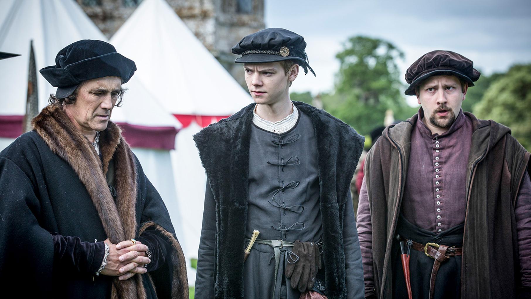 Cromwell stands outside tents with Rafe and Richard Cromwell