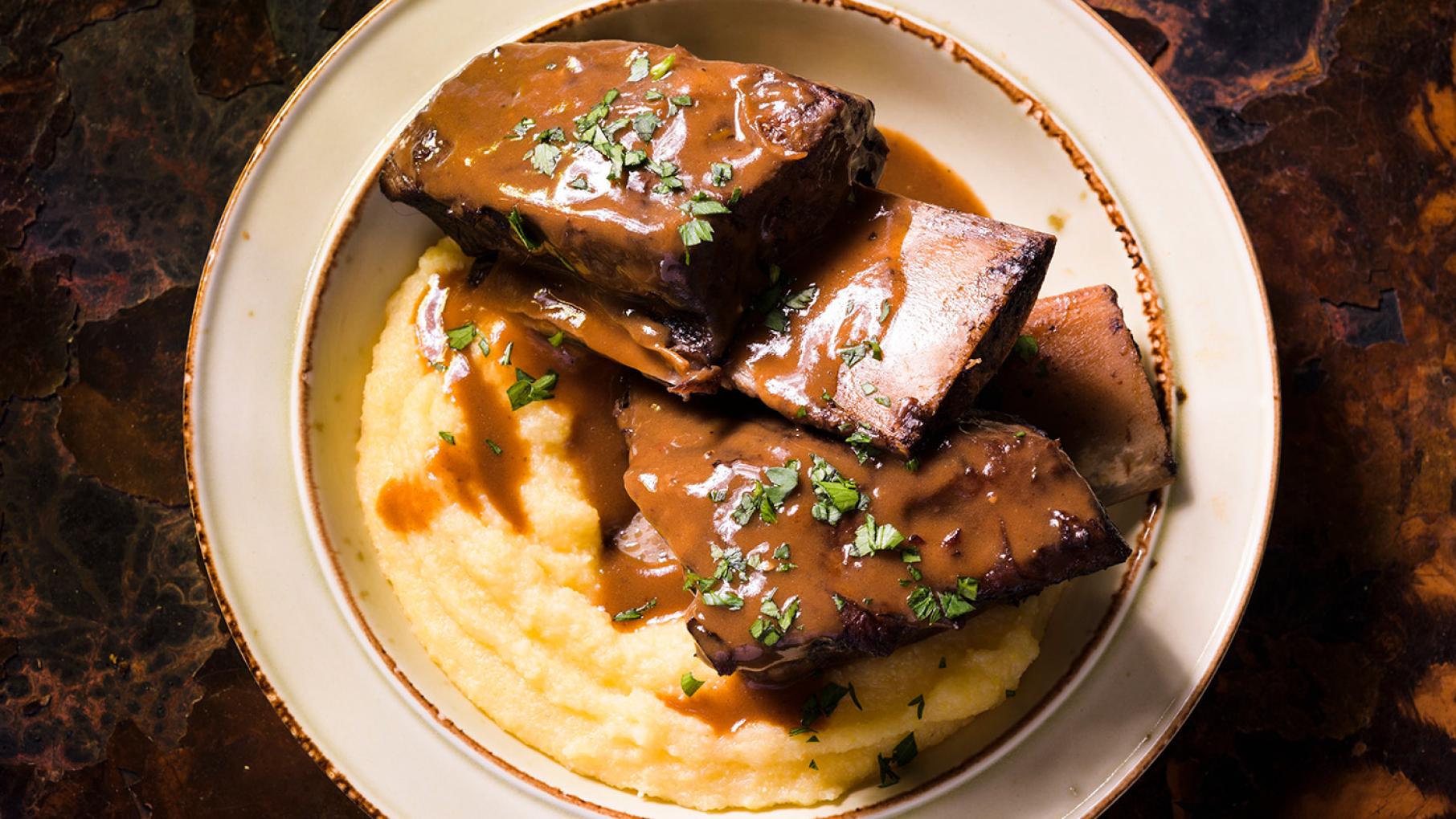 Short ribs in a dish on top of polenta