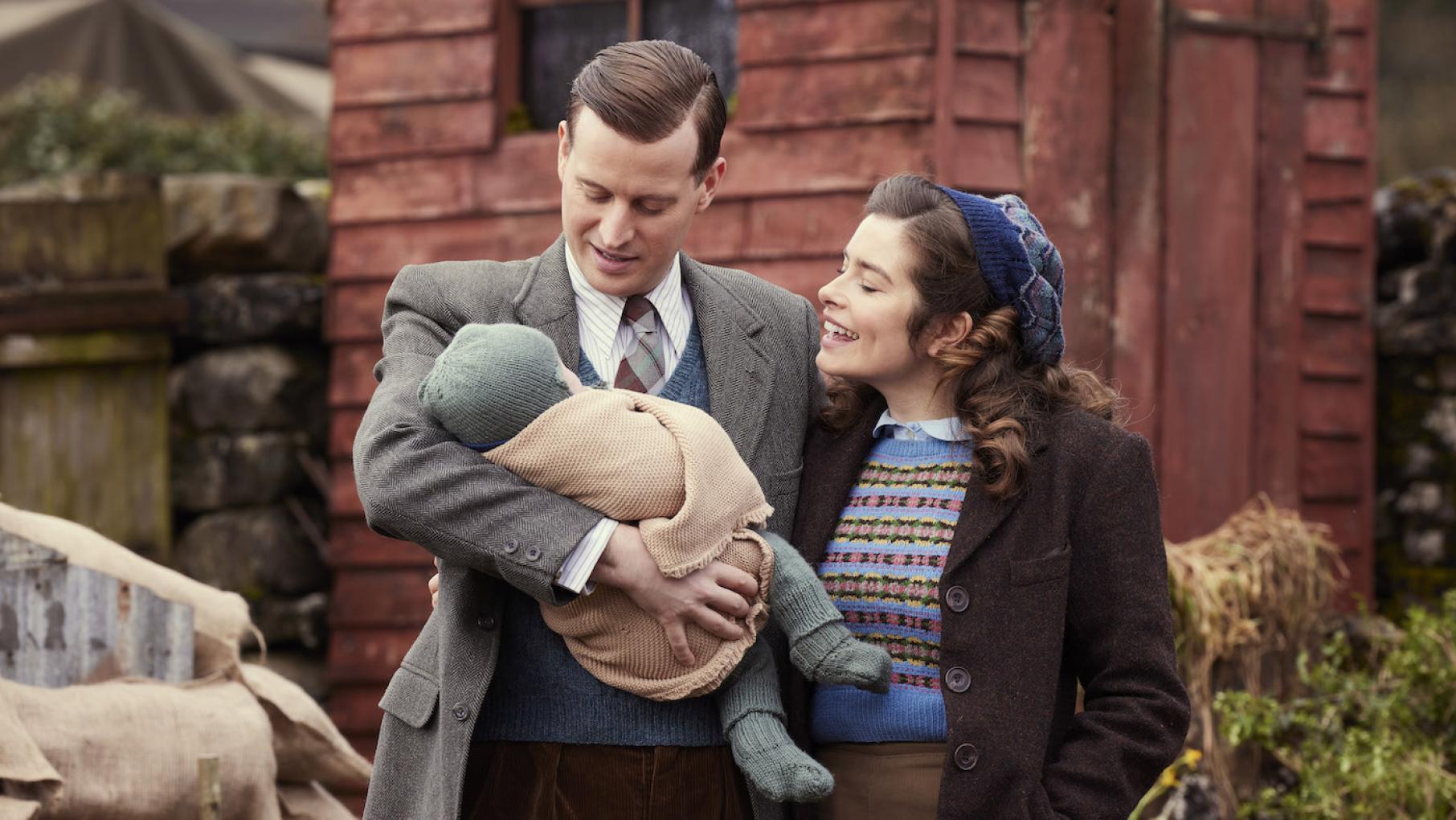 'All Creatures Great and Small' returns with a fifth season. Credit: Helen William, Playground Entertainment, and Masterpiece James holds his son while Helen stands next to him looking on