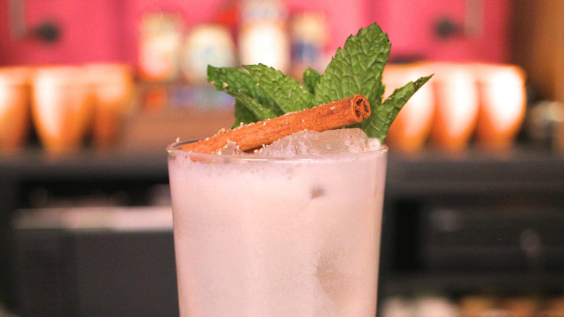 A drink topped with a cinnamon stick and mint