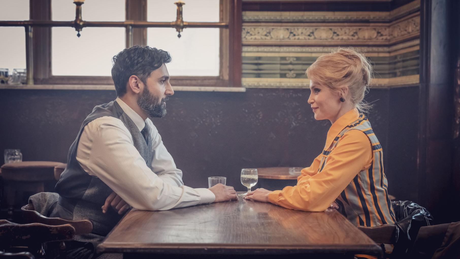 Dennis and Barbara sit across from each other at a pub table with drinks