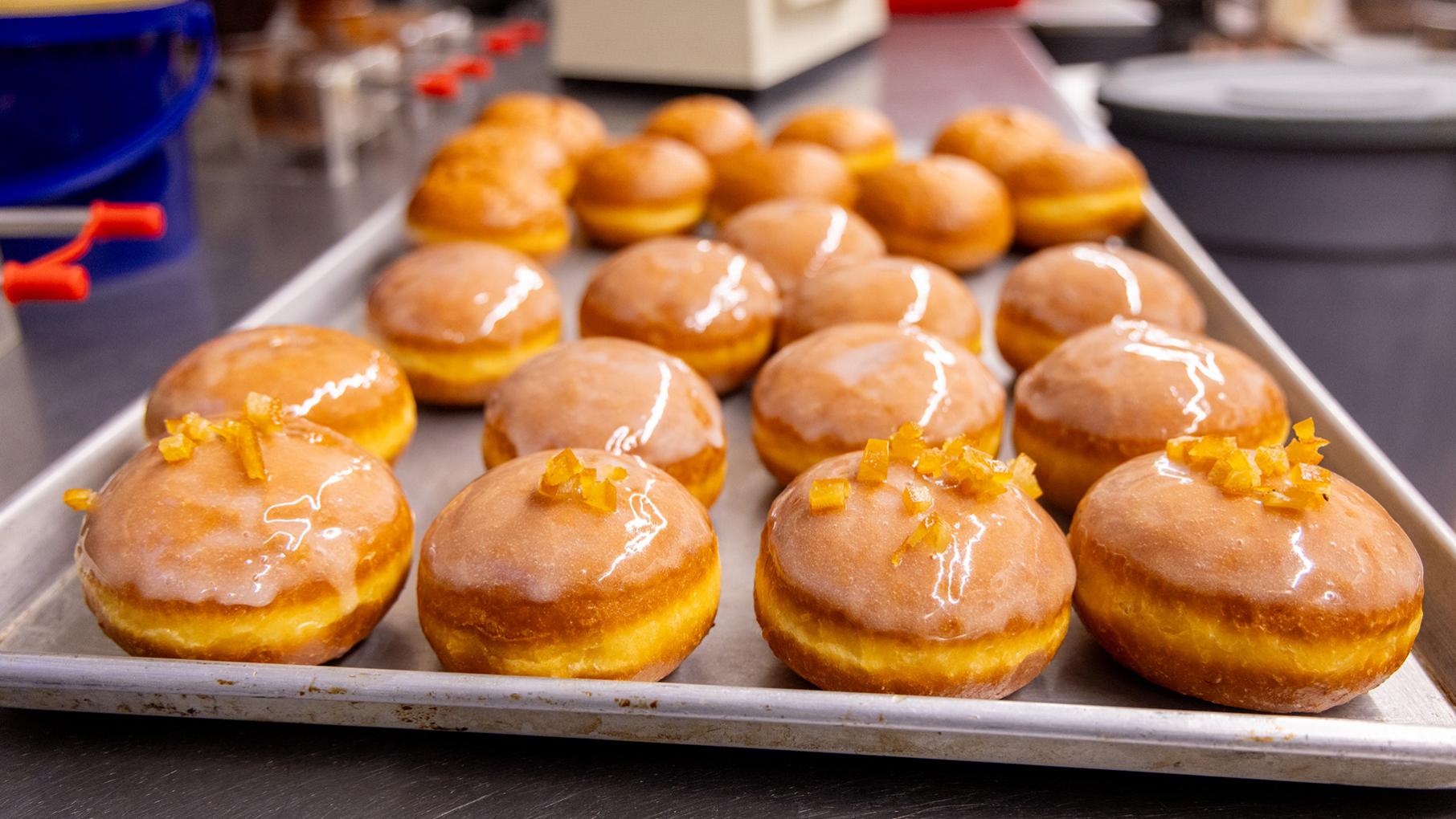 Pączki at Delightful Pastries, which makes some 40,000 of the Polish treat at this time of year. Credit: Kathleen Hinkel for WTTW A baking sheet filled with paczki