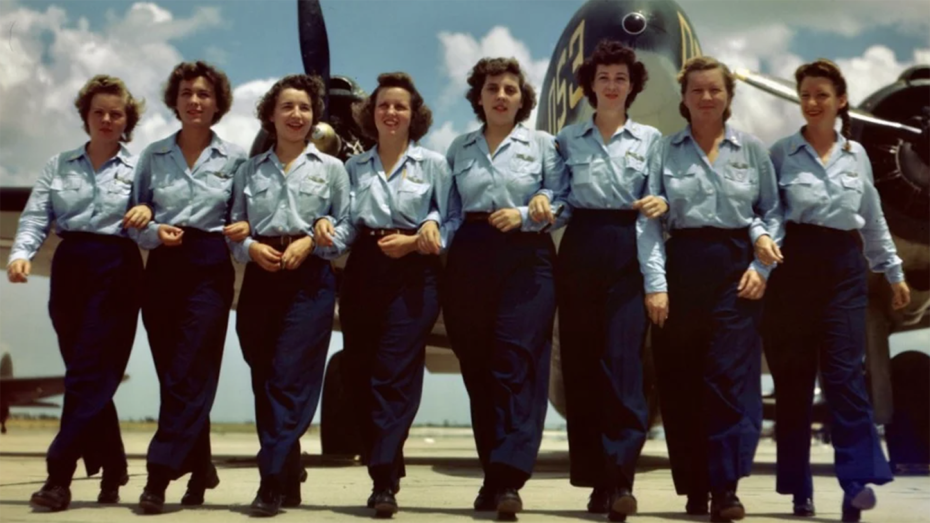 Credit: Women of World War II: The Untold Stories An old photo of women during World War II dressed in uniform, all linking arms in front of an airplane