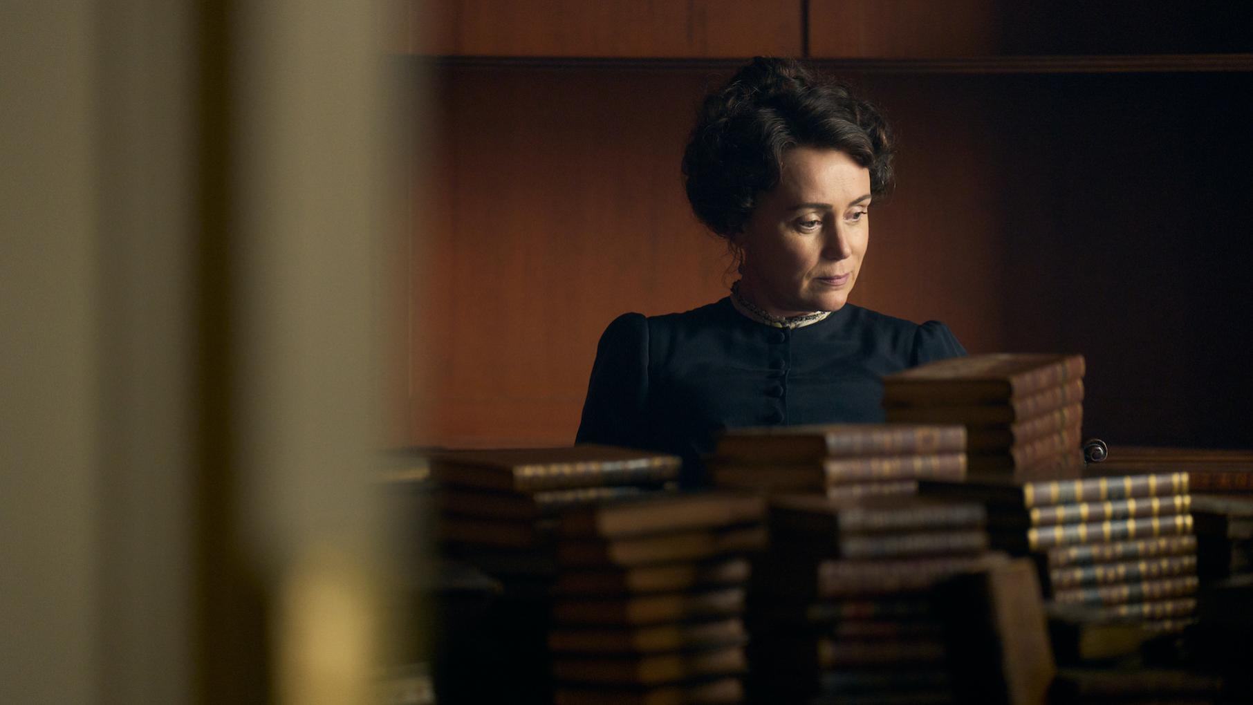 Keeley Hawes as Cassandra Austen behind piles of books
