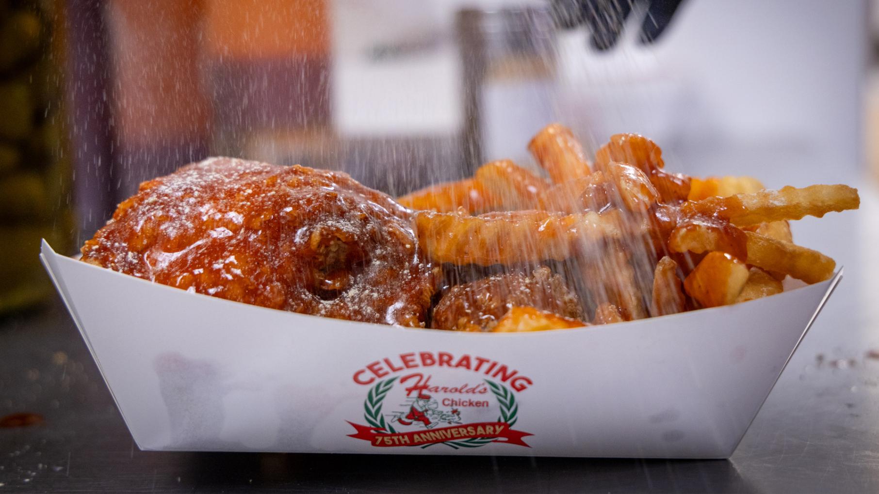 Harold’s Chicken Shack was founded 75 years ago by a Black entrepreneur who came to Chicago from Alabama. Now it’s a legendary part of Chicago. Photo: Kathleen Hinkel for WTTW A paper dish of fried chicken and fries is sprinkled with lemon pepper
