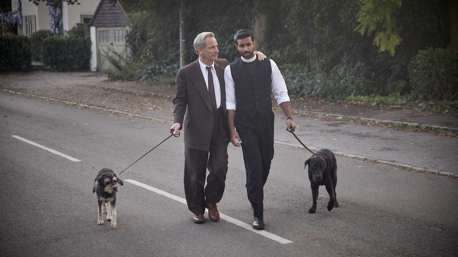 Geordie and Alphy are returning to solve more crimes in a tenth season of 'Grantchester.' Credit: Kudos, ITV, and Masterpiece Geordie and Alphy walk dogs down the street