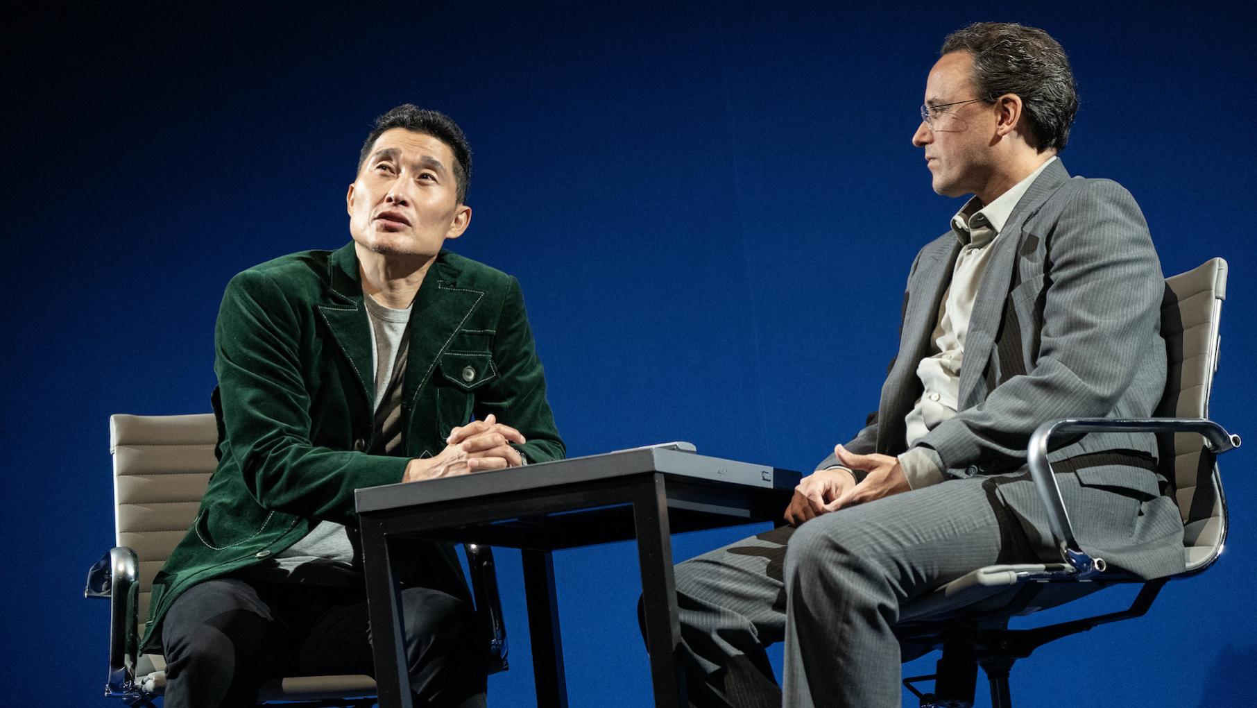 Two men sit at a table