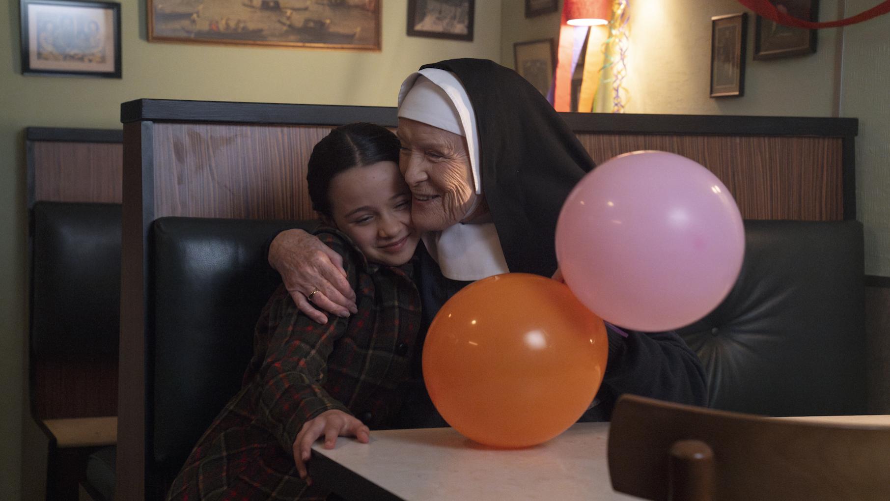 Nancy's wedding is to take place in Poplar, but there's a surprise. Credit: BBC Studios Sister Monica Joan hugs Colette in a dining booth with two balloons