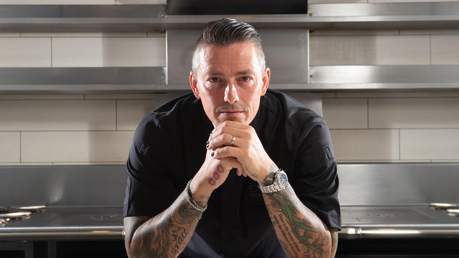“I felt like maybe if I get it on paper and I’m able to actually put it away, maybe that will help," decorated chef Curtis Duffy says of exploring his traumatic past in a memoir. Credit: Provided Curtis Duffy leans on his hands and stares at the camera from a stainless steel kitchen