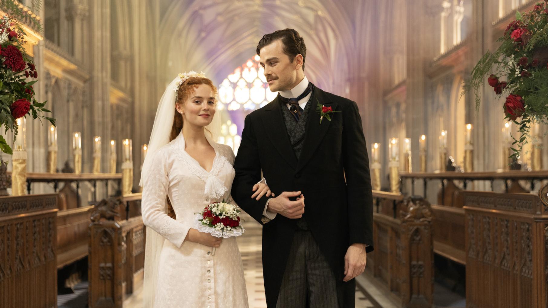 A bride and groom stand in an ornate, light-filled church