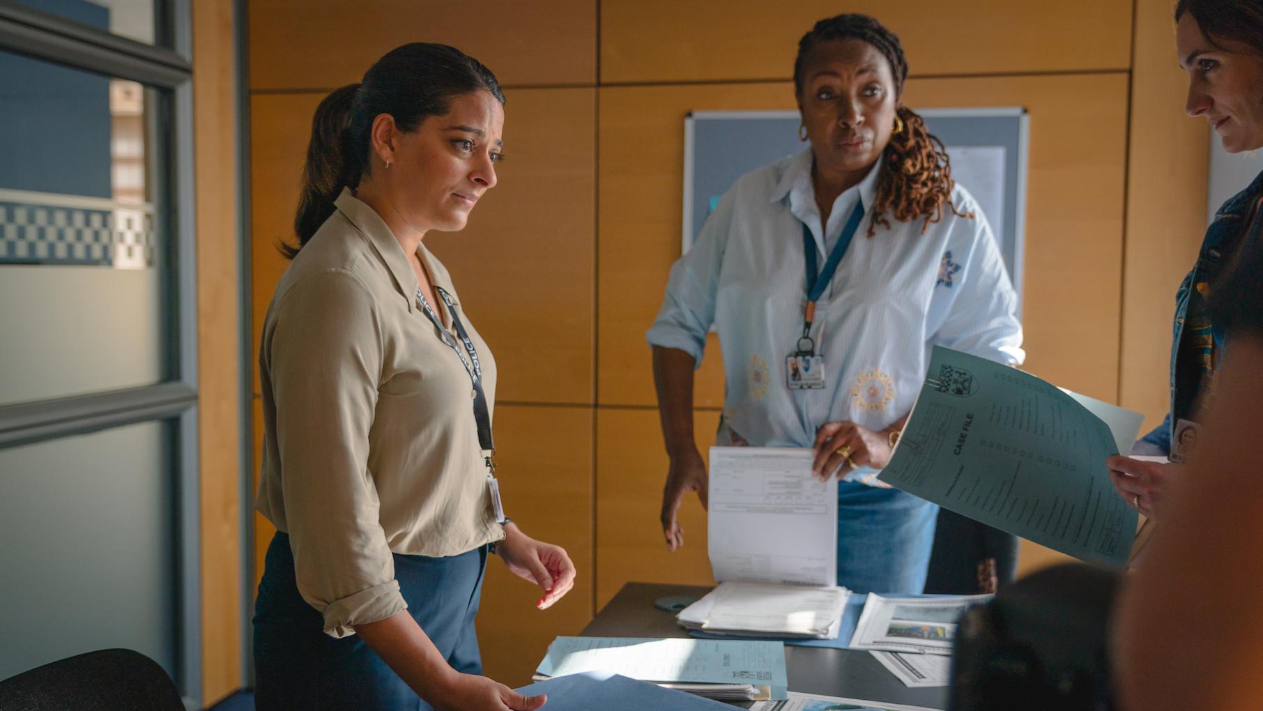 Tanika stands with Suzie and Becks in a room 